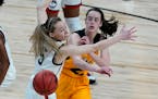 Iowa's Caitlin Clark, right, passes the ball around UConn's Paige Bueckers back when the two squared off in the 2021 Sweet 16 in San Antonio, the only