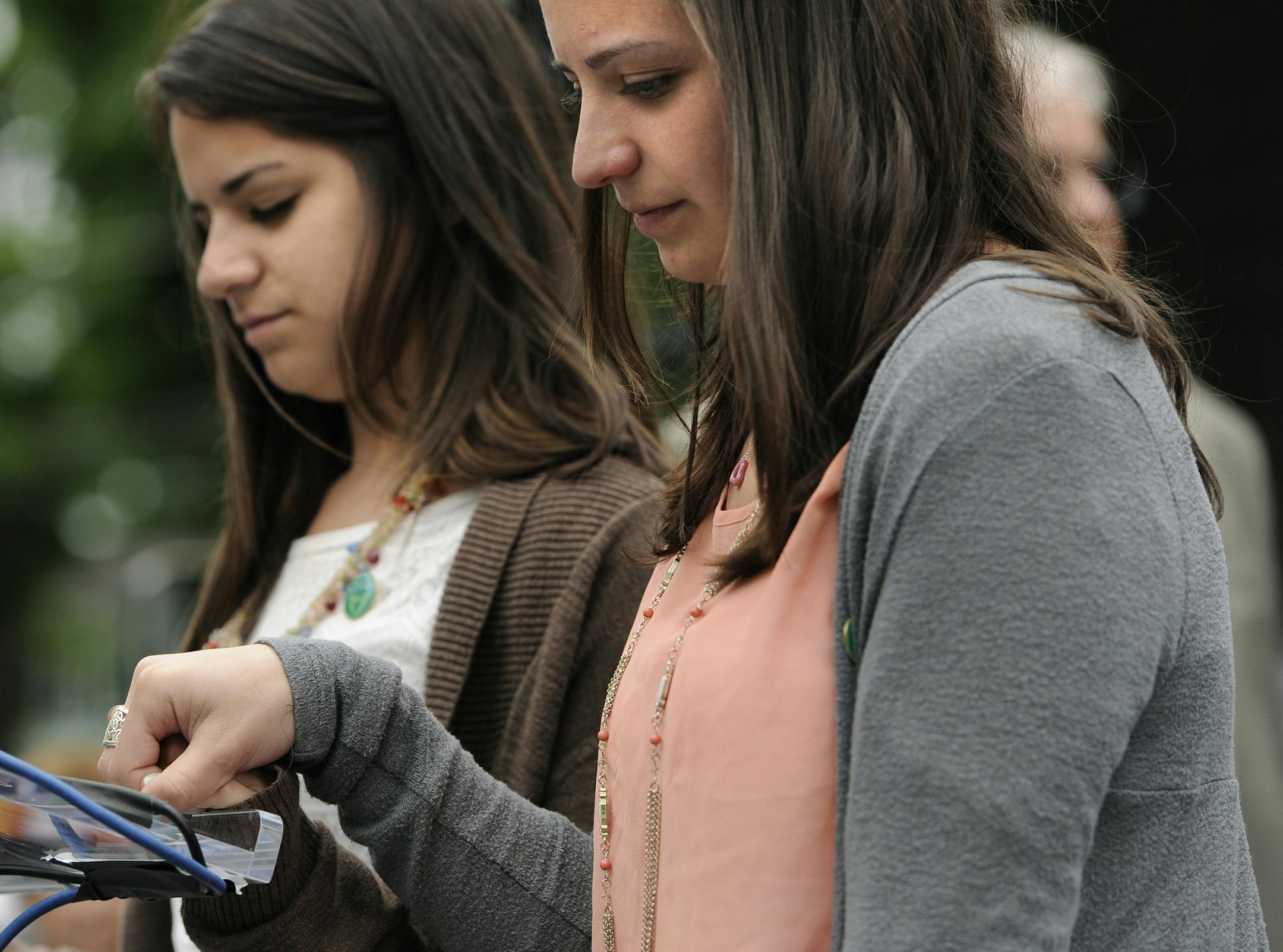 Carlee Soto, left, and Jillian Soto, sisters of slain teacher Victoria Soto, hold hands during a 26-second moment of silence at Edmond Town Hall honoring the 20 children and six adults gunned down at Sandy Hook Elementary School on Dec. 14, 2012 in Newtown, Conn., Friday, June 14, 2013. Newtown held a moment of silence Friday for the victims of the massacre at Sandy Hook Elementary School at a remembrance event that doubled as a call to action on gun control, with the reading of names of thousan