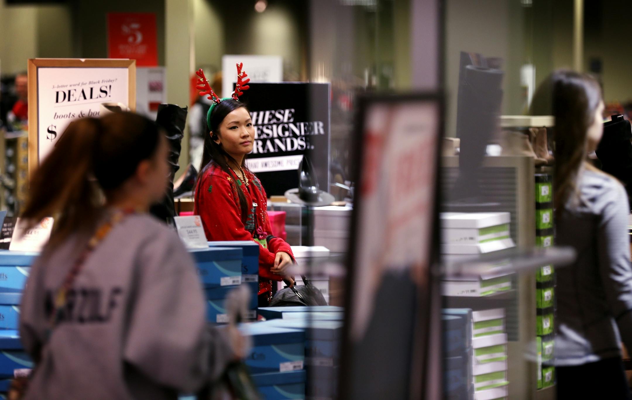 An employee greets customers at DSW Designer Shoe Warehouse on Black Friday at Mall of America in Bloomington on Friday, November 28, 2014.
