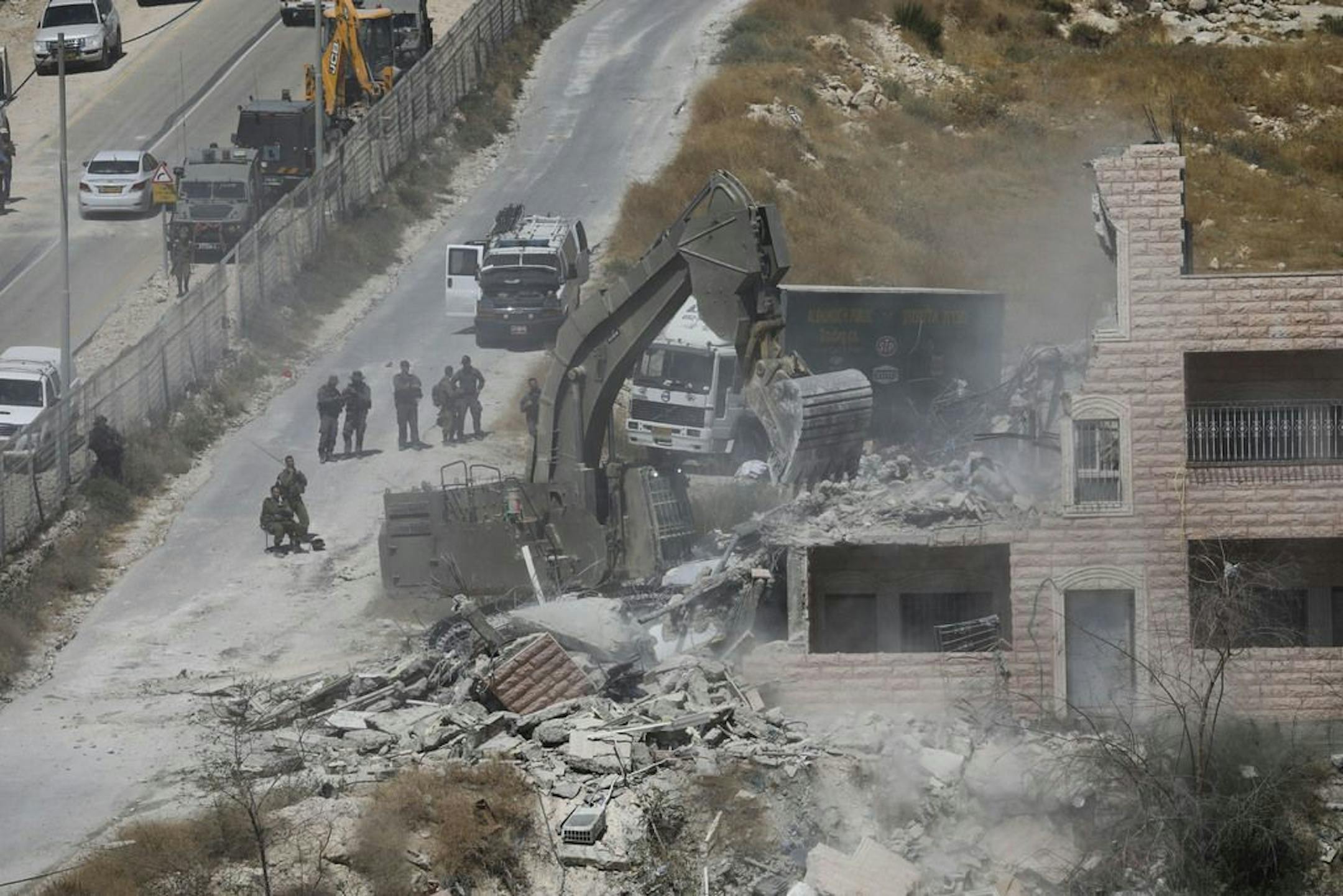 Israeli forces destroy a building in a Palestinian village of Sur Baher, east Jerusalem, Monday, July 22, 2019. Israeli work crews have begun demolishing dozens of Palestinian homes in an east Jerusalem neighborhood. Monday's demolitions cap a years-long legal battle over the buildings, which straddle the city and the occupied West Bank.