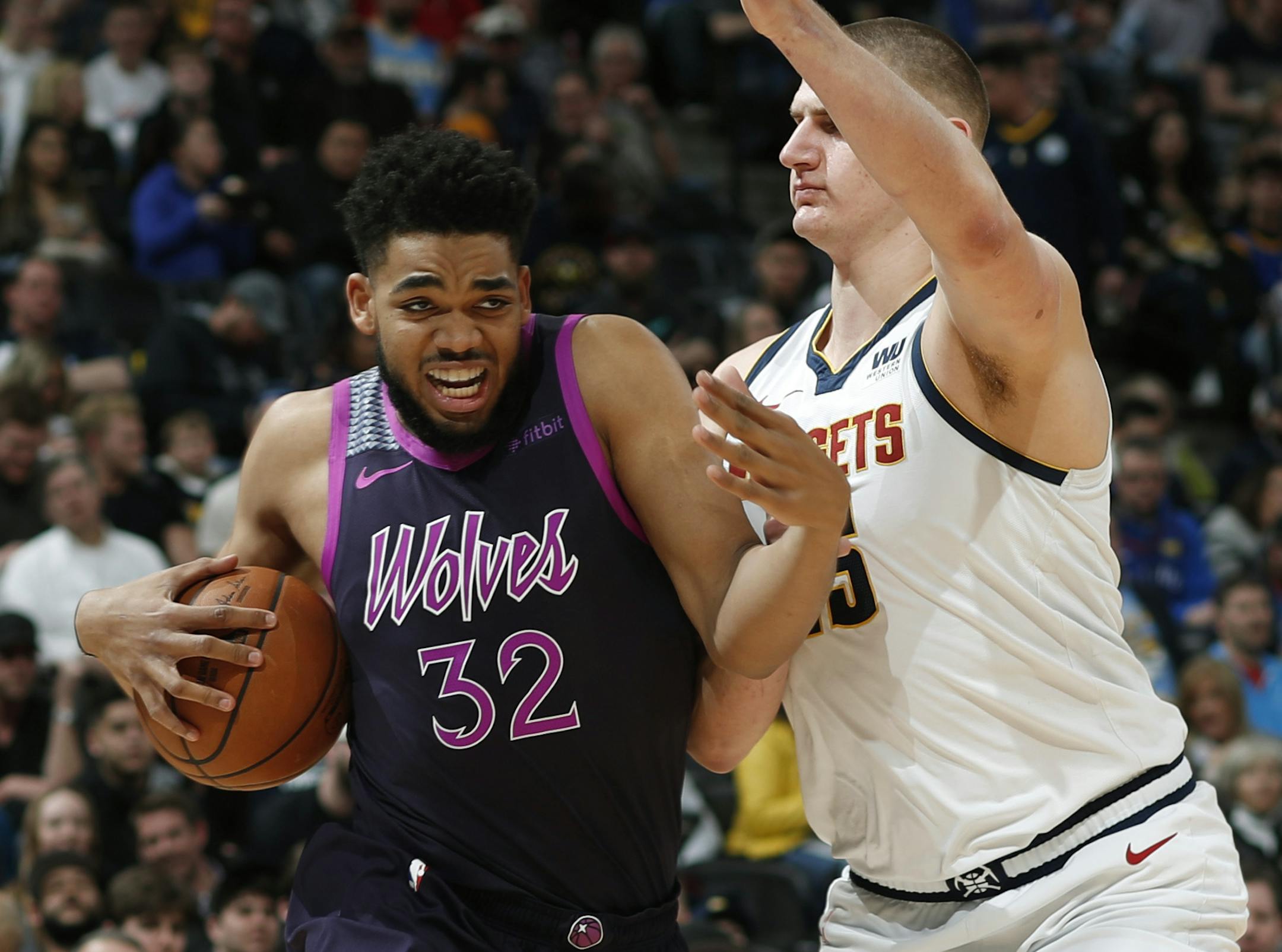 Minnesota Timberwolves center Karl-Anthony Towns, left, drives to the rim as Denver Nuggets center Nikola Jokic defends in the first half of an NBA basketball game, Tuesday, March 12, 2019, in Denver. (AP Photo/David Zalubowski)