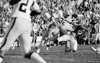 Wide receiver Sammy White of the Minnesota Vikings loses his helmut as two Oakland Raiders defenders hit him during Super Bowl XI in Pasadena, Calif.,