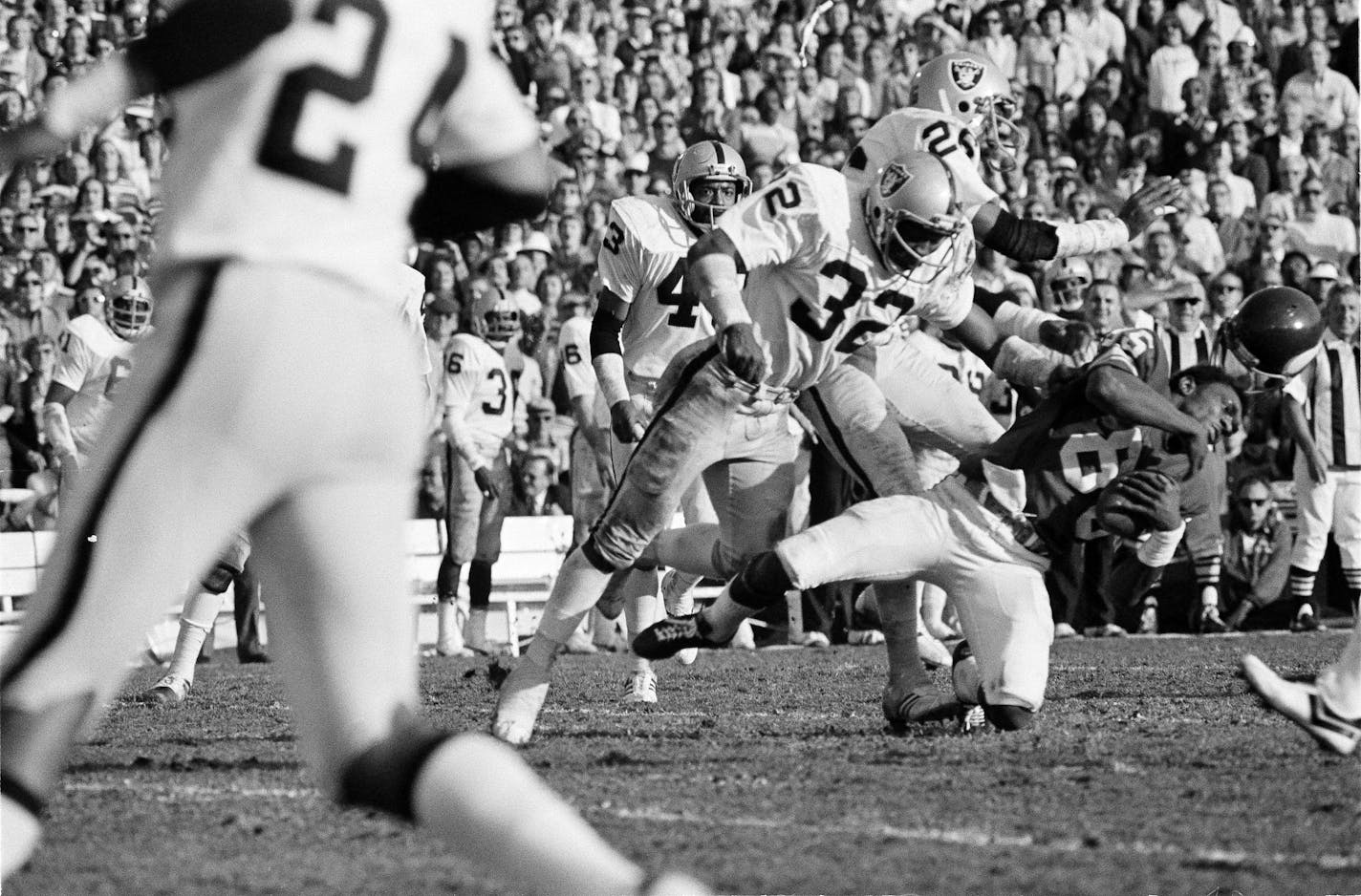 Wide receiver Sammy White of the Minnesota Vikings loses his helmut as two Oakland Raiders defenders hit him during Super Bowl XI in Pasadena, Calif., Jan. 9, 1977. (AP Photo)