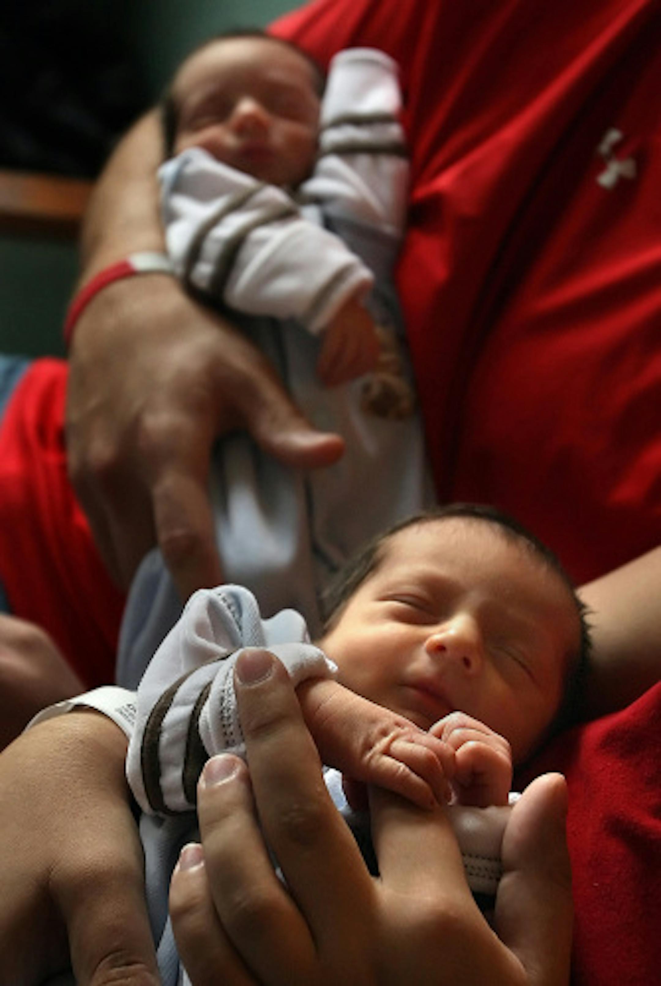 Identical twins Owen John (right) and Gavin Joseph Cassellius were held by their parents, Jeff (left) and Jeana in their room at Abbott Northwestern Hospital in Minneapolis. The babies were born Wednesday.