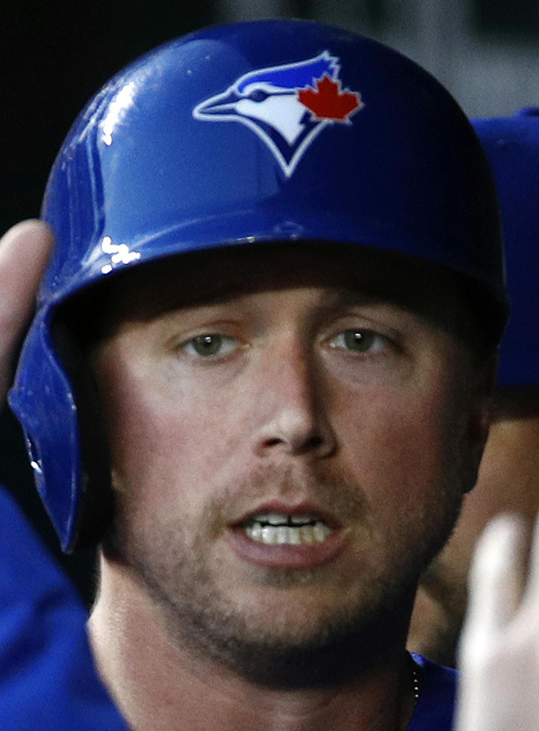 Toronto Blue Jays' Justin Smoak high-fives teammates in the dugout after scoring on a single by Kevin Pillar in the first inning of a baseball game against the Baltimore Orioles, Wednesday, April 11, 2018, in Baltimore. (AP Photo/Patrick Semansky)