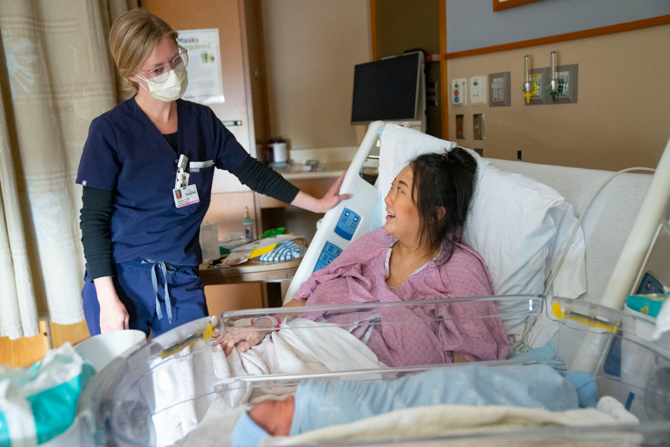Andrea Anderson, RN, talks to Kao Her about what types of tests to expect for her newborn son, Atticus Vang, Thursday, March 24, 2022 at Maple Grove Hospital in Maple Grove, Minn.