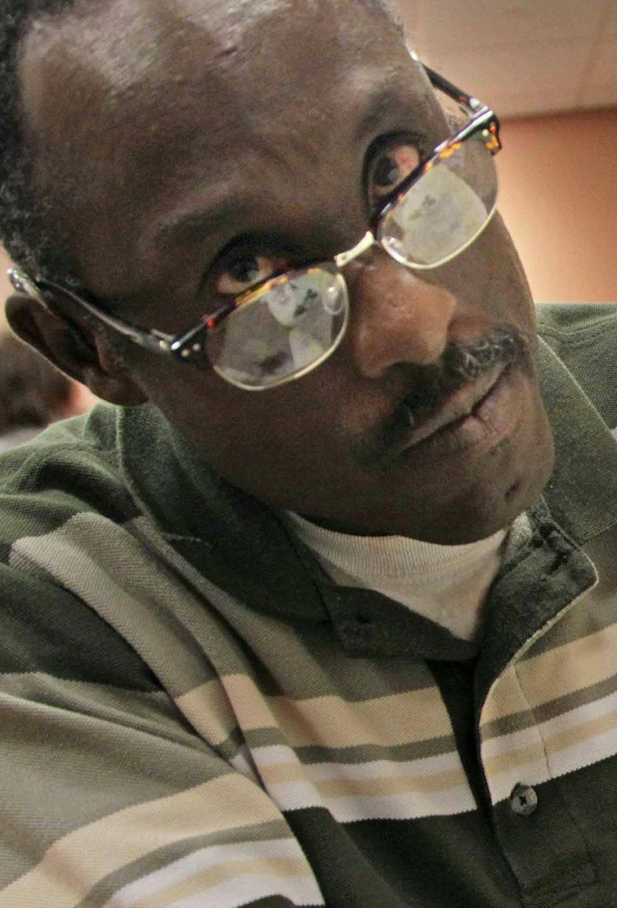 Selris James, left, looks at his published book of drawings on Oct. 27, 2015 at Bascom Palm Eye Institute in Miami. (Carl Juste/Miami Herald/TNS) ORG XMIT: 1175843