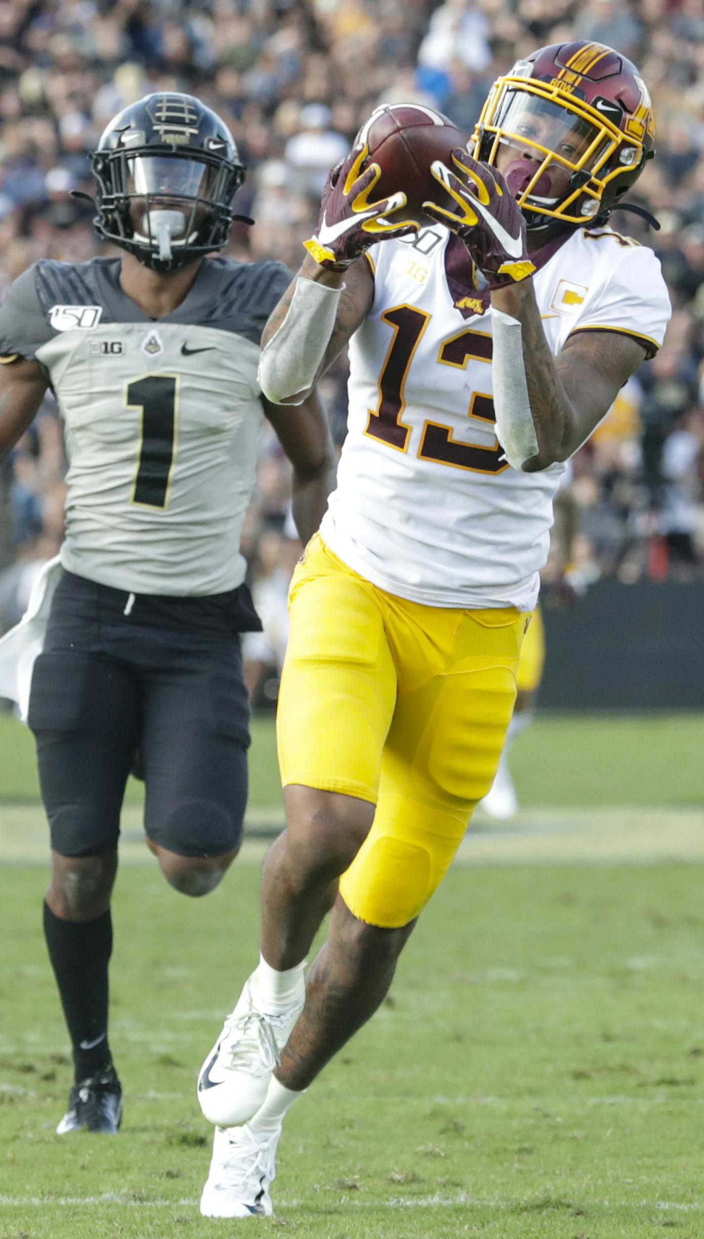 Minnesota wide receiver Rashod Bateman (13) makes a catch in front of Purdue cornerback Dedrick Mackey (1) on his way to a touchdown during the second half of an NCAA college football game in West Lafayette, Ind., Saturday, Sept. 28, 2019. Minnesota defeated Purdue 38-31. (AP Photo/Michael Conroy)