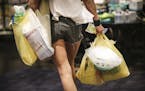 A woman carried plastic bags of groceries out of Kowalski's in Uptown in Minneapolis, Minn., on Thursday, July 23, 2015. ] RENEE JONES SCHNEIDER &#x20
