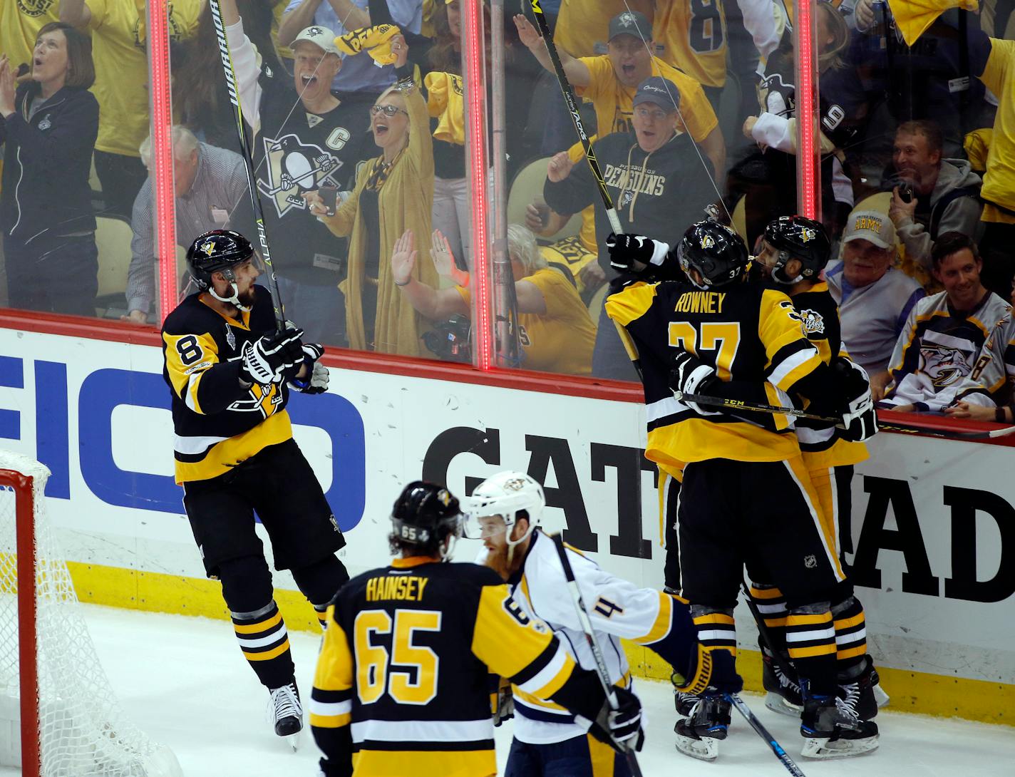 Pittsburgh Penguins' Brian Dumoulin (8) and Carter Rowney (37) celebrate with Nick Bonino after Bonino's goal against the Nashville Predators during the first period in Game 1 of the NHL hockey Stanley Cup Final, Monday, May 29, 2017, in Pittsburgh. (AP Photo/Gene J. Puskar)