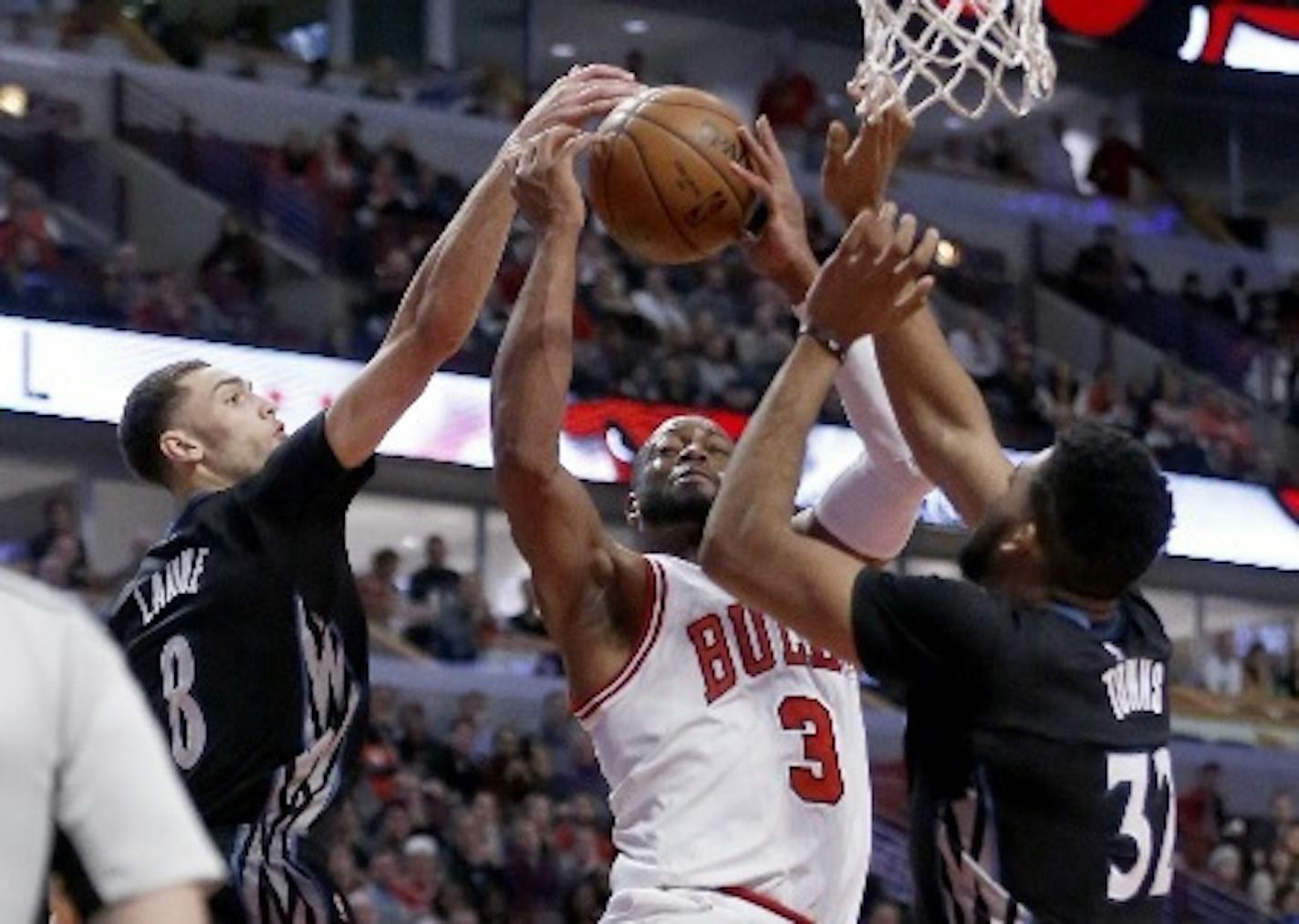 The Wolves' Zach LaVine (8) blocked the shot of the Bulls' Dwyane Wade as Karl-Anthony Towns also defended last season.