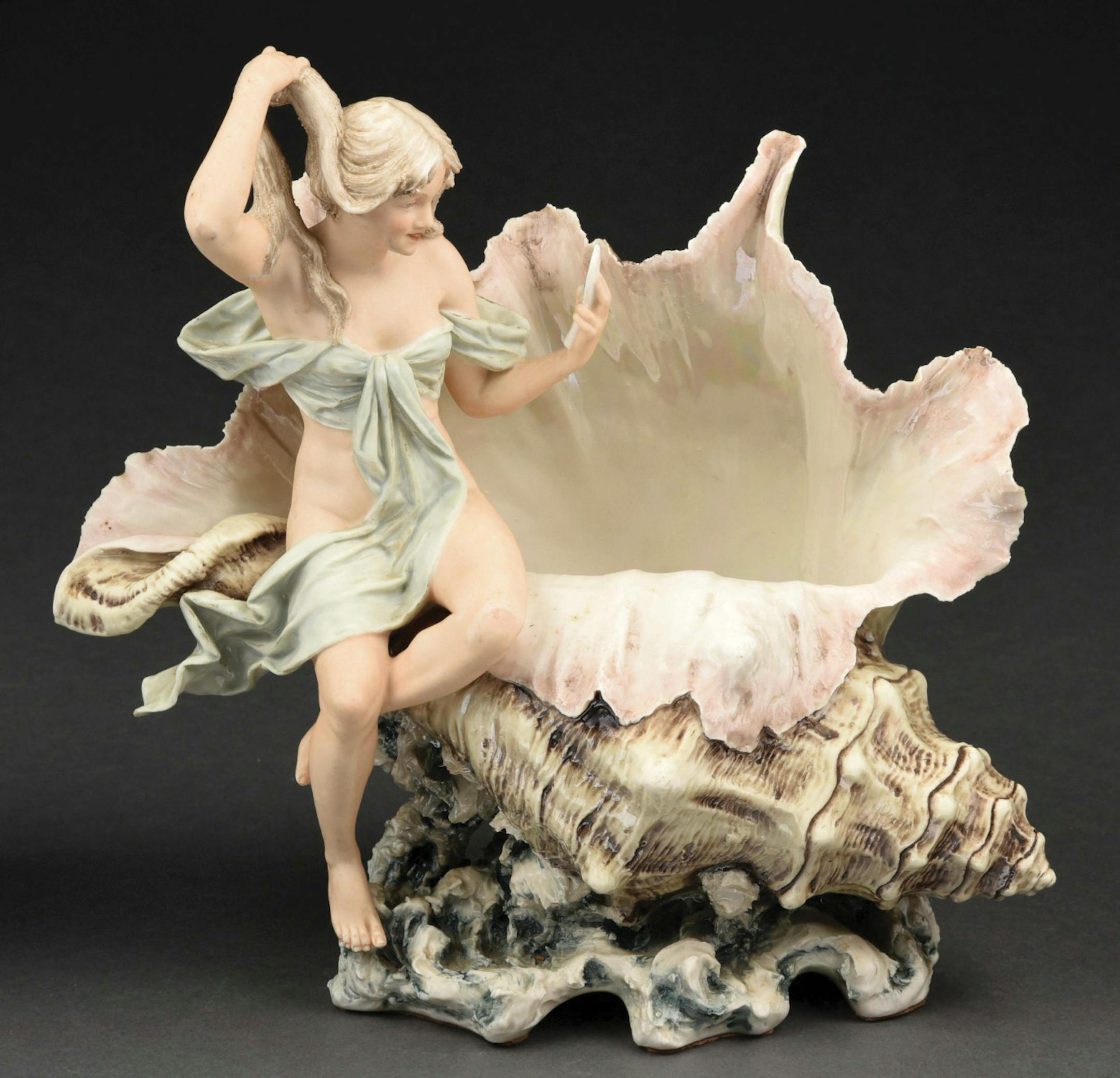 Some collectibles are found in nature; some imitate them. If it weren't for the attached figure, this Royal Dux porcelain vase might pass for a real conch shell.