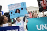 Erin Longbottom, left, holds up a sign in support of birth control access during a rally outside the Supreme Court in Washington, Wednesday, March 23, 2016, as the court hears arguments to allow birth control in healthcare plans in the Zubik vs. Burwell case. The Supreme Court seems deeply divided over the arrangement devised by the Obama administration to spare faith-based groups from having to pay for birth control for women covered under their health plans. (AP Photo/Jacquelyn Martin)