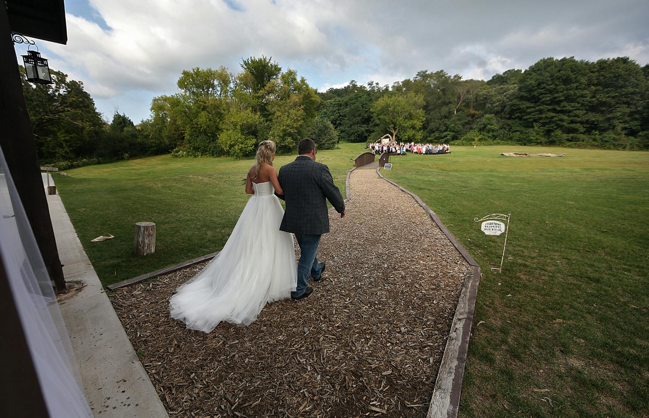Bride Savannah Koehnen walked with her father, Gary Koehnen, up a path to join others in the wedding party, including groom Jeremy Eckert.