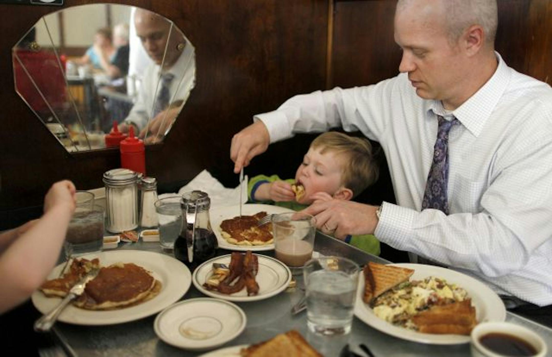Weekend breakfasts at the Modern Cafe are all about no-frills scratch cooking. On a recent Saturday morning, Aaron Olson cuts a pancake into toddler-sized bites for his hungry 2-year-old son, Nathan. They were sharing a booth with Nathan's 5-year old brother, Emmet, and the boys' grandmother, Lilly Olson.