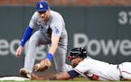 Atlanta Braves' Eddie Rosario dives into second base ahead of the tag by Los Angeles Dodgers second baseman Trea Turner off a pop out by Freddie Freem
