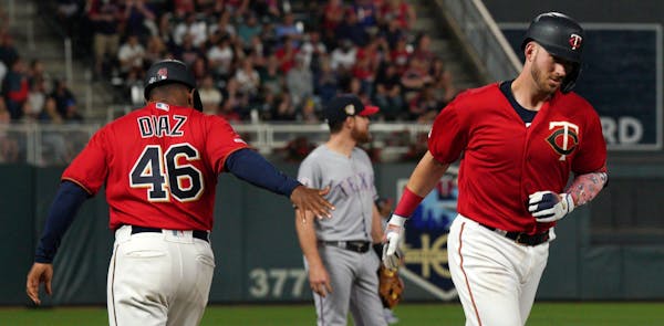 Minnesota Twins catcher Mitch Garver (18) celebrated with Minnesota Twins third base coach Tony Diaz (46) after hitting a home run in the seventh inni