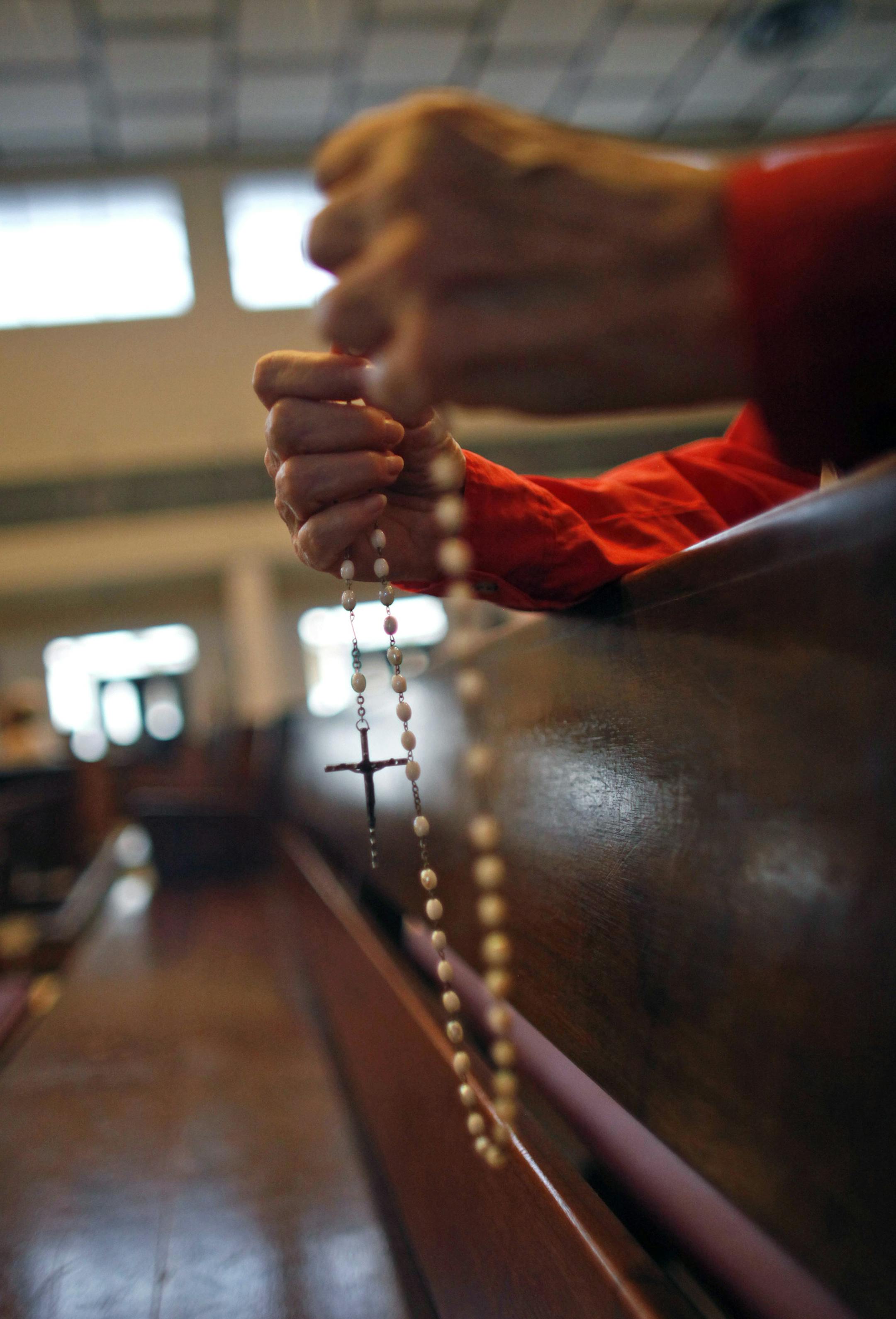A woman prays the rosary during a Mass in honor of Archbishop Roberto Gonzalez Nieves at a church in San Juan, Puerto Rico, Wednesday, May 8, 2013. Roman Catholics in Puerto Rico rallied Wednesday around the archbishop who is apparently under pressure from the Vatican to resign for allegedly covering up for sexually abusive priests and other misdeeds. Archbishop Roberto Gonzalez Nieves has not confirmed that he is being asked to step down as leader of the Catholic Church in the U.S. island terri