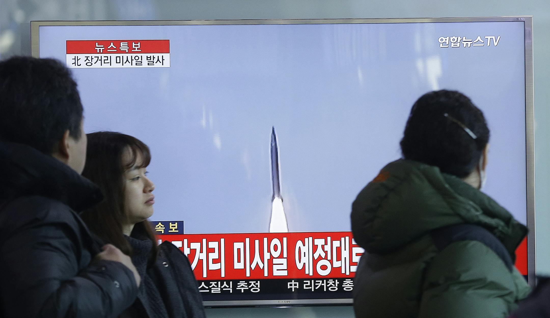 South Koreans watch a TV news program with a file footage about North Korea's rocket launch at Seoul Railway Station in Seoul, South Korea, Sunday, Feb. 7, 2016. North Korea on Sunday defied international warnings and launched a long-range rocket that the United Nations and others call a cover for a banned test of technology for a missile that could strike the U.S. mainland. The letters on the screen read: " North Korea launched a long-range missile." (AP Photo/Ahn Young-joon) ORG XMIT: MIN20160