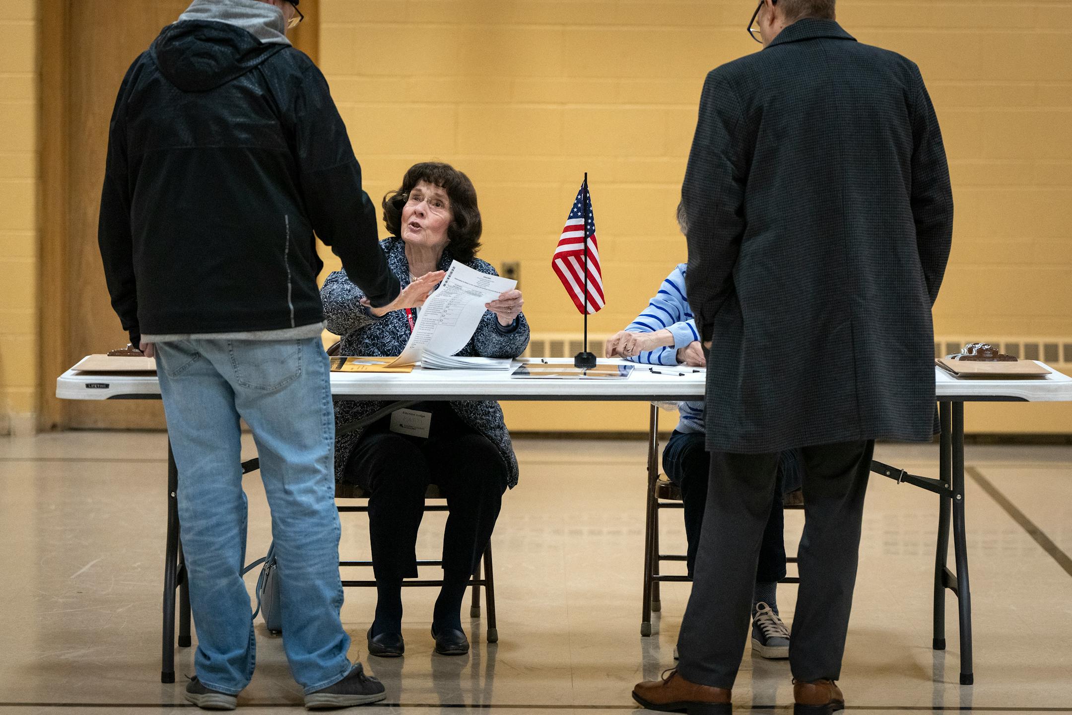 Volunteer Marty Rossmann helps voters at Gloria Dei Lutheran Church in Ward 3 of St. Paul.