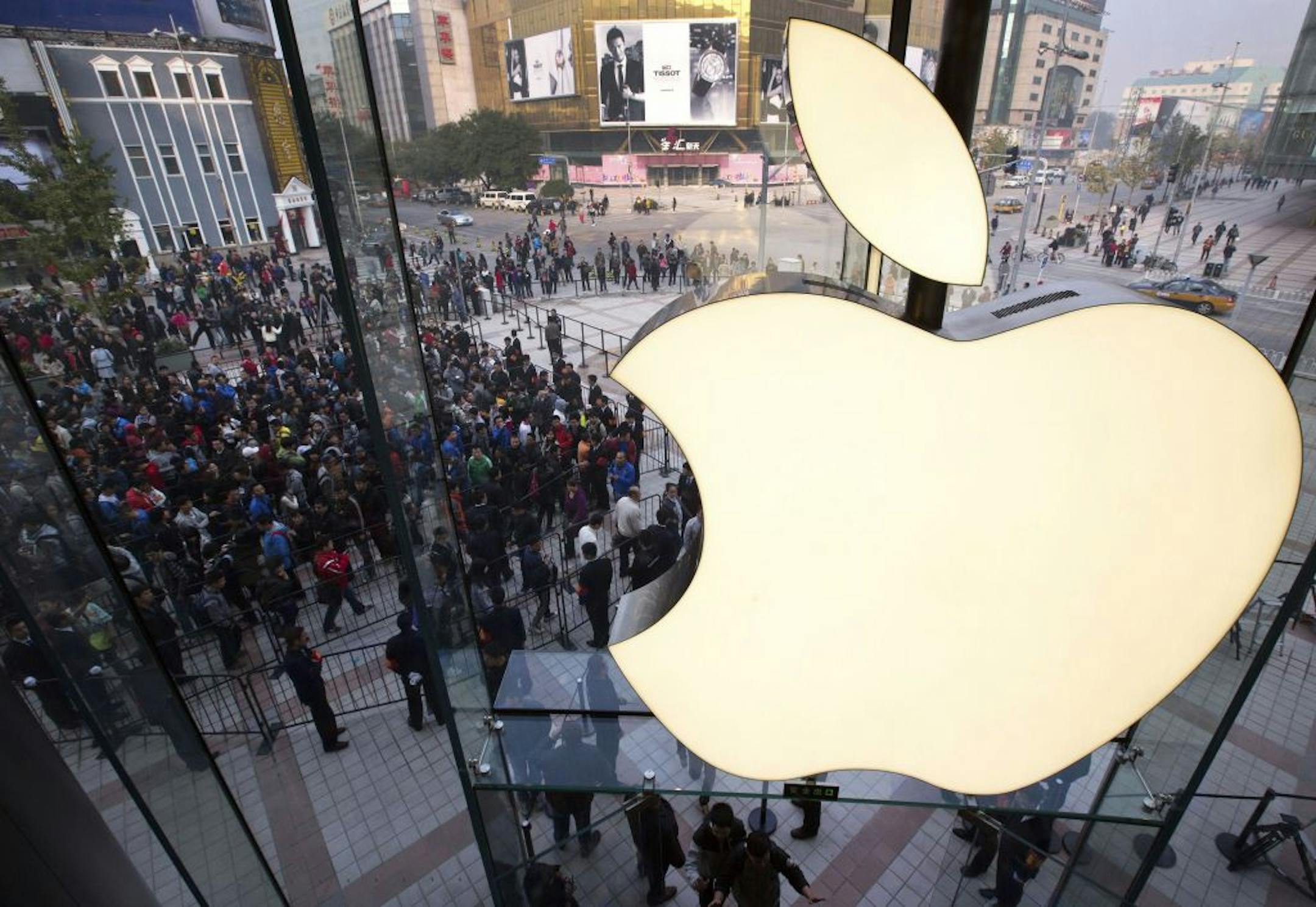 FILE - In this Oct. 20, 2012 photo, people line up to enter a newly-opened Apple Store in Wangfujing shopping district in Beijing. Apple's profit surge halted in the latest quarter, as a flood of new products like the iPhone 5 meant high start-up costs for new production lines. Apple posted net income for the October to December quarter that was flat with the year before. It was the first time in years that Apple didn't post a double-digit earnings increase.
