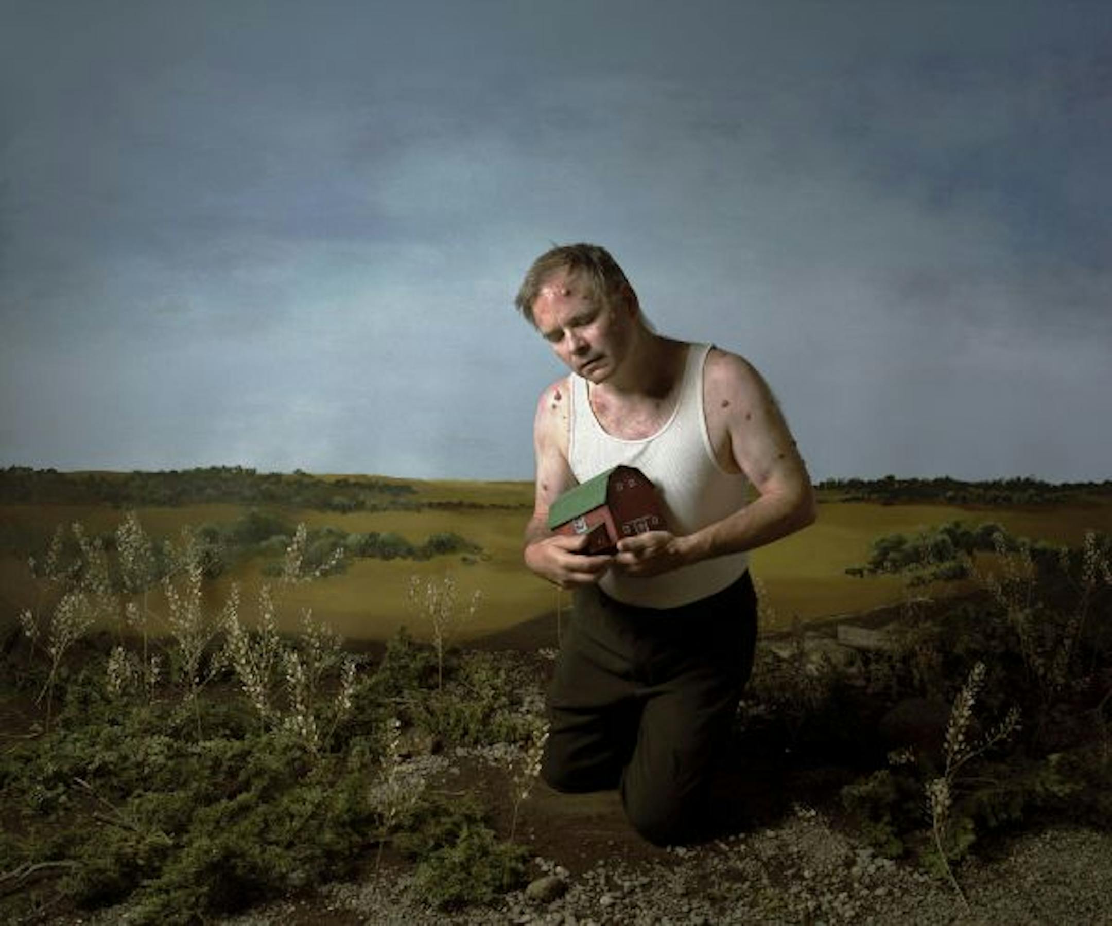 A contemporary Midwestern "Job" clutches a symbolic barn in Sara Belleau's staged photo.