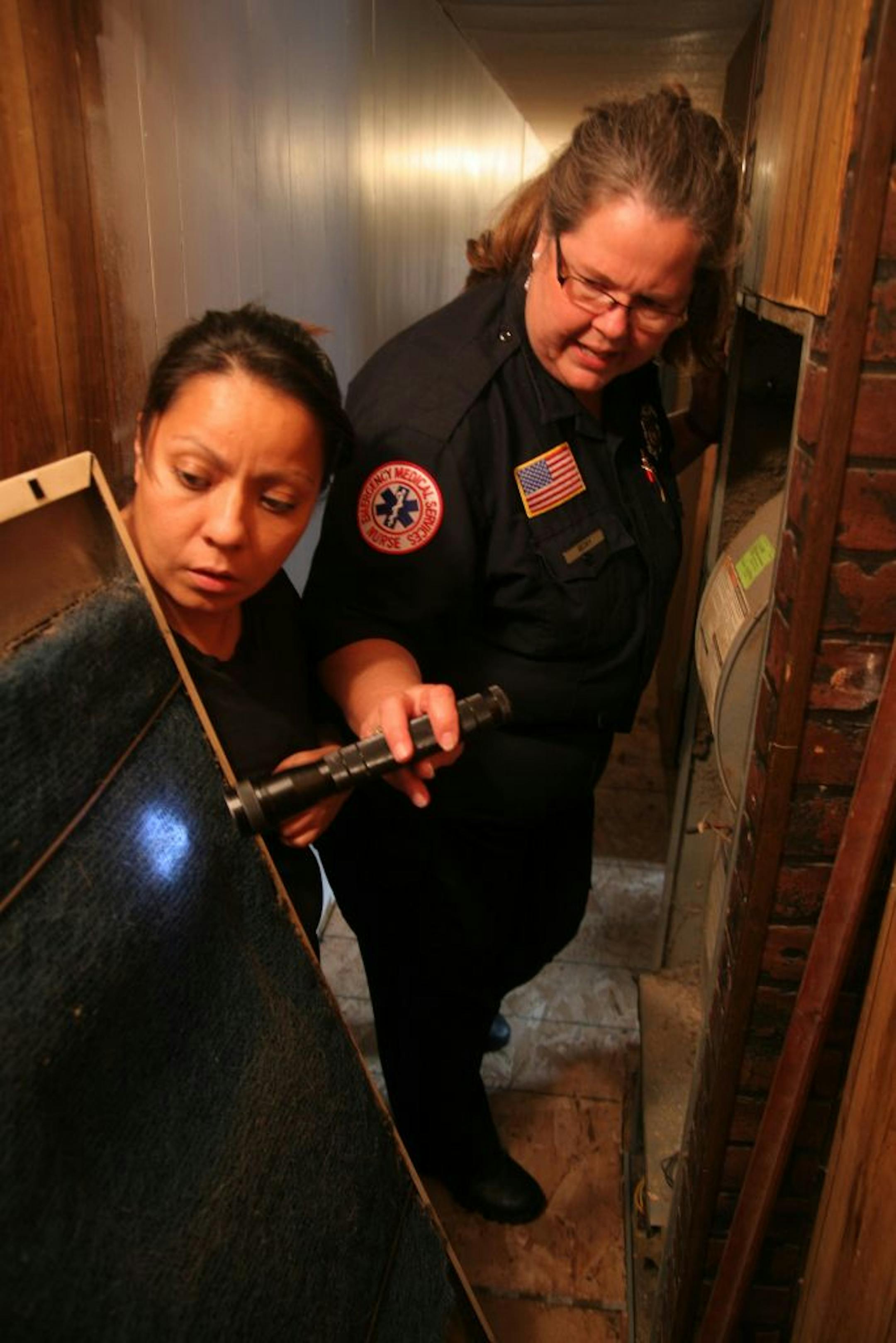 0153: Becky Booker, a Public Educator for the Spring Lake Park-Blaine-Mounds View Fire Department talked with homeowner Mariela Jorge about the importance of keeping her furnace filter clean, because anytime there's lint, there's fuel for a fire. Photo: Maria Baca - Star Tribune