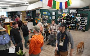 Shop owner Steve Schreader talks with customers during the May 17 grand opening of Lake State Mountaineering in the Minneapolis' North Loop. Schreader