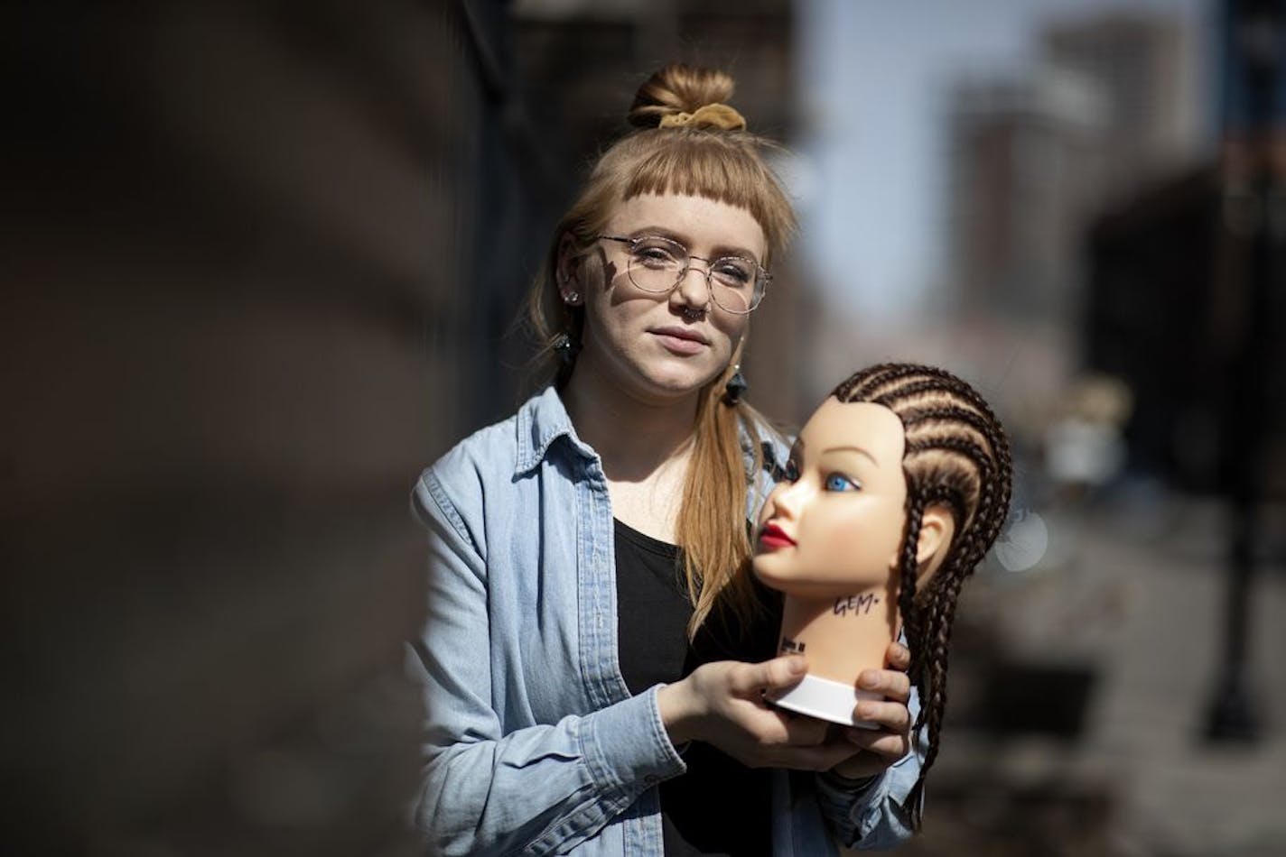 Gem Russell is a student at Aveda Institute. Because of coronavirus, this aspiring hair stylist is compelled to practice on a mannequin instead of an actual client.