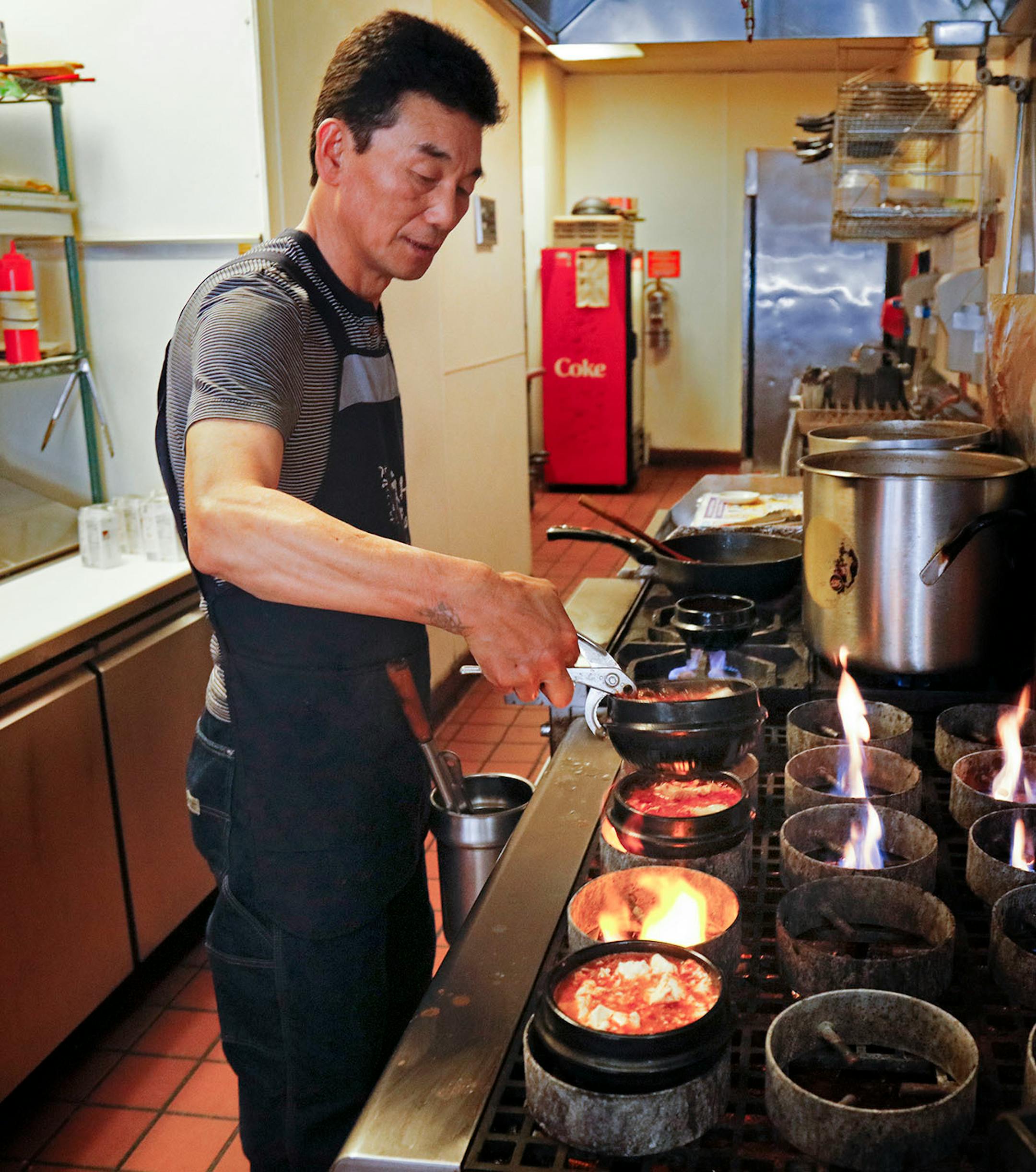 Kim Pong-Yun owner chef of the Kimchi Tofu House, cooks through the lunch hour. It is near the U of M in Minneapolis, specializes in spicy Korean soup called sundubu. It sells 12 varieties and customers can choose the level of spiciness, done by varying the amount of Korean chili flakes called gochugaru. ] Star Tribune/Tom Wallace • tom.wallace@startribune.com