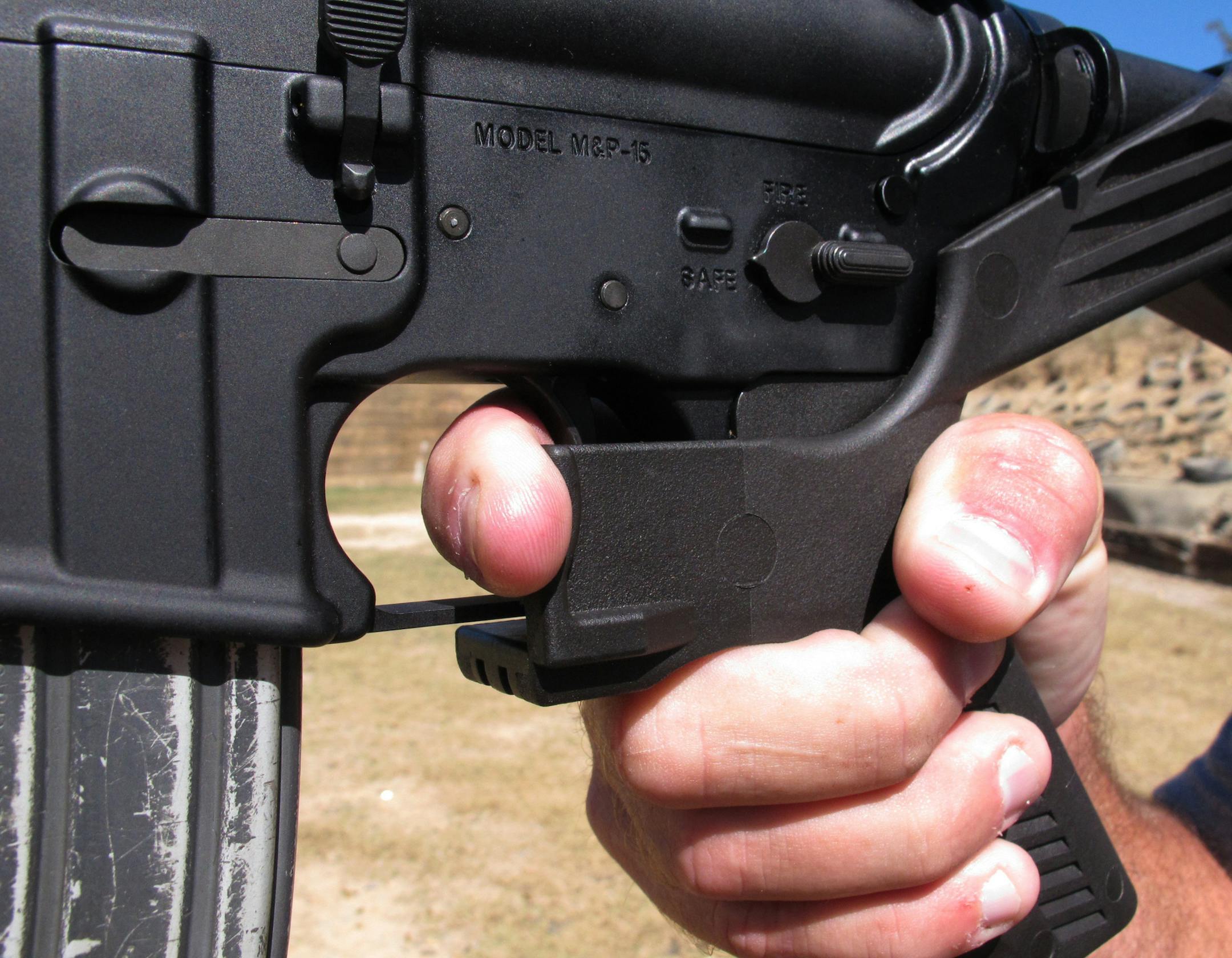 Shooting instructor Frankie McRae illustrates the grip on an AR-15 rifle fitted with a "bump stock" at his 37 PSR Gun Club in Bunnlevel, N.C., on Wednesday, Oct. 4, 2017. The stock uses the recoil of the semiautomatic rifle to let the finger "bump" the trigger, making it different from a fully automatic machine gun, which are illegal for most civilians to own. (AP Photo/Allen G. Breed)