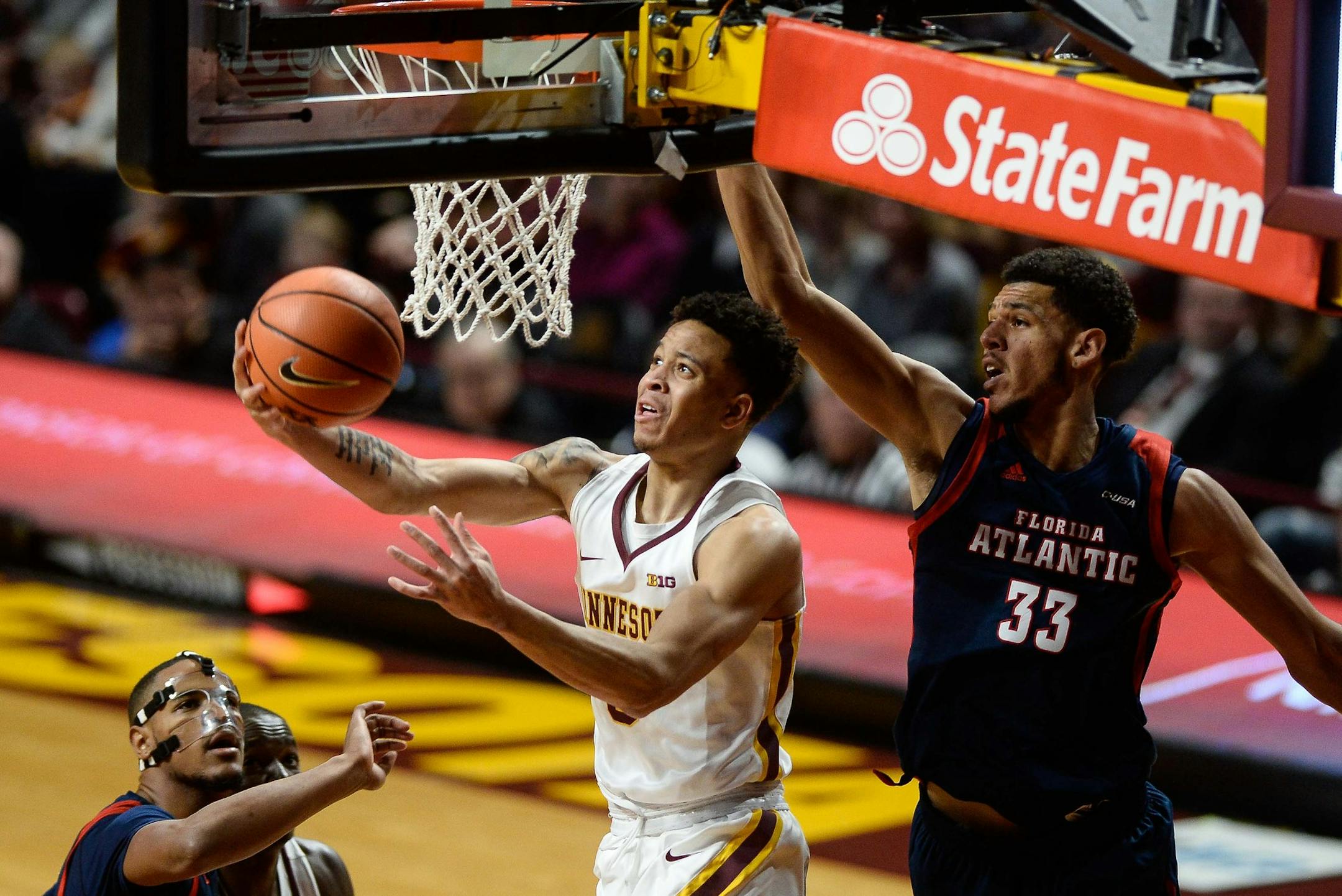 Minnesota Golden Gophers guard Amir Coffey (5) scored a reverse layup while being defended by Florida Atlantic Owls center Ronald Delph (33) in the first half. ] AARON LAVINSKY ï aaron.lavinsky@startribune.com The University of Minnesota Golden Gophers men's basketball team played the Florida Atlantic University Owls on Saturday, Dec. 23, 2017 at Williams Arena in Minneapolis, Minn.