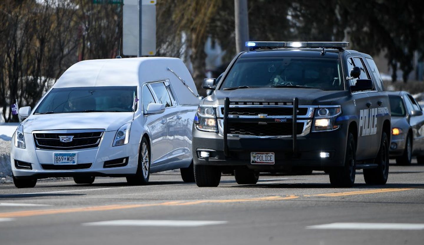 A hearse made a wide turn around a Farmington Police vehicle stopped at 220th Street West and Chippendale Avenue during a funeral procession in Farmington Tuesday afternoon.