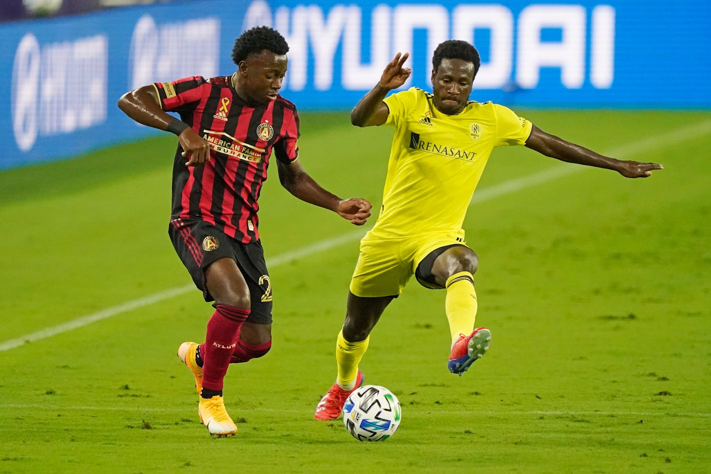 Atlanta United defender George Bello, left, and Nashville SC forward Abu Danladi, right, battle during the first half of an MLS soccer match Saturday, Sept. 12, 2020, in Nashville, Tenn. (AP Photo/Mark Humphrey)