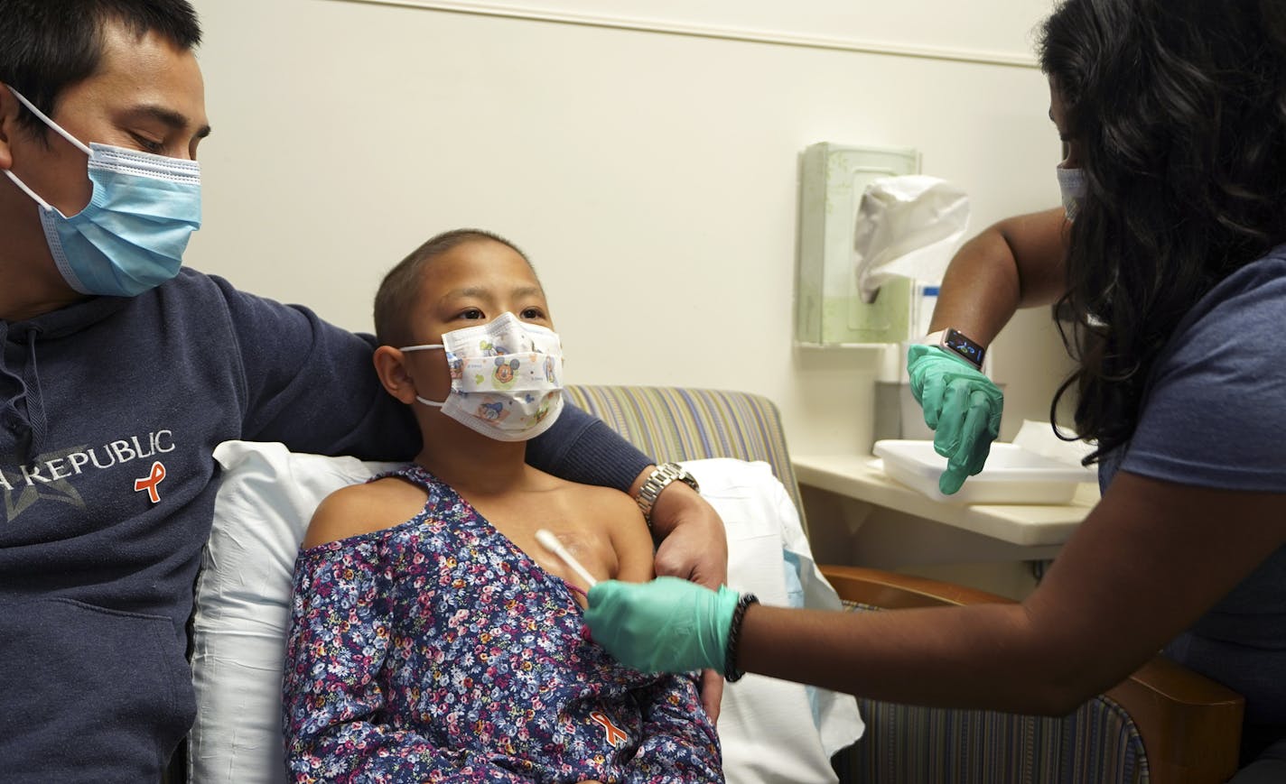 8 year old JoJo Truong sits next to her dad Jerome Truong, from Eagan getting the numbing cream before her injection as part of the Comfort Promise at the Cancer and Blood Disorders Clinic at Children&#x2019;s Minnesota. Nurse in photos is Trinayani Freeberg, RN. ] Needles cause fear and anxiety for children, and their parents, but Children's Minnesota is reporting success in overcoming that obstacle. The pediatric provider is reporting results from the nation's first systemwide approach to elim