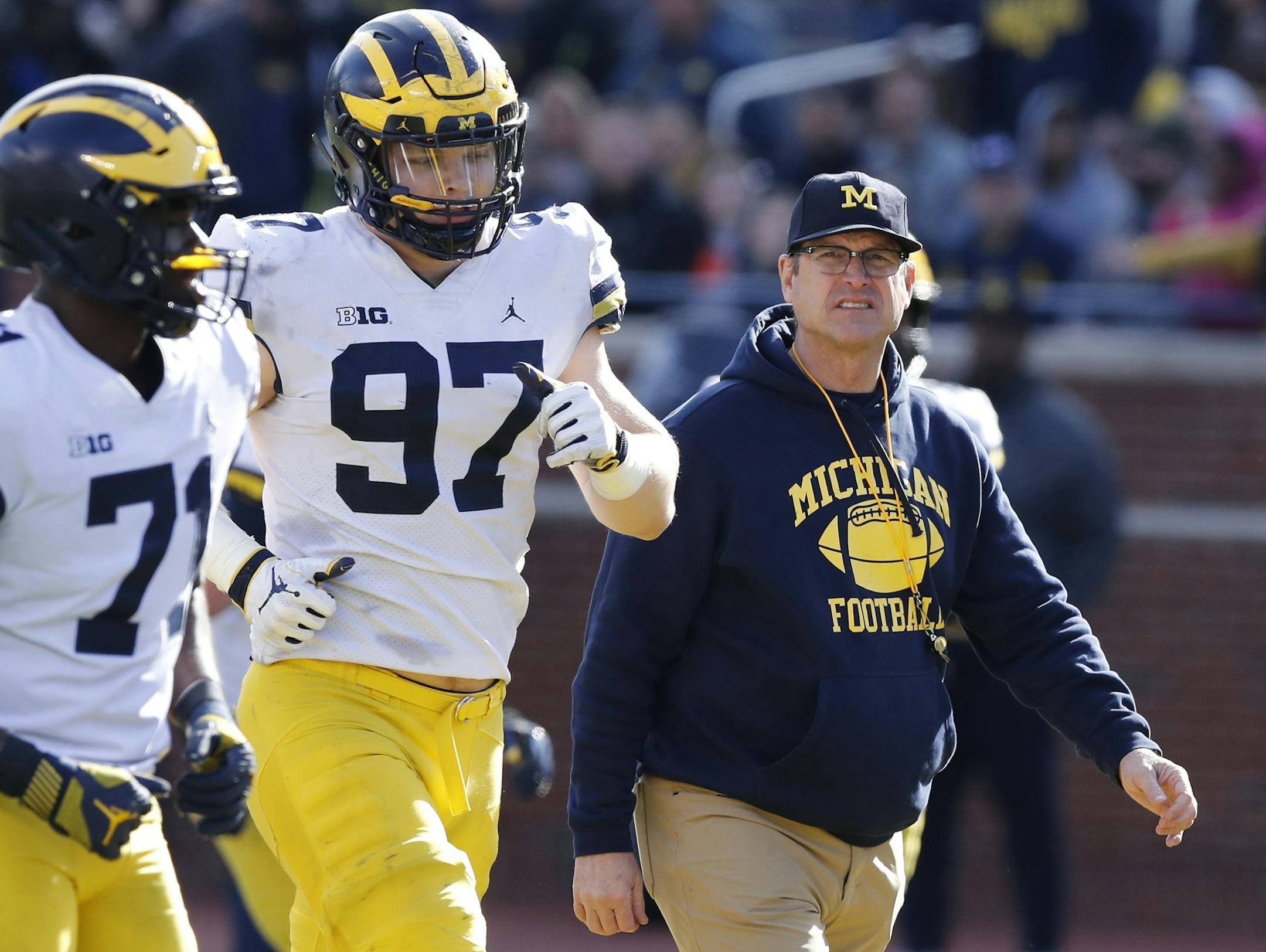 FILE- In an April 13, 2019, file photo, Michigan head coach Jim Harbaugh walks out with players during the team's annual spring NCAA college football game in Ann Arbor, Mich. Harbaugh seems to be set up for success at Michigan in his fifth season, leading a program that is a popular choice to win the Big Ten. "That's where I would pick us," Harbaugh said. Some are predicting the Wolverines will earn a spot in the College Football Playoff to give them a chance to win a national championship for t