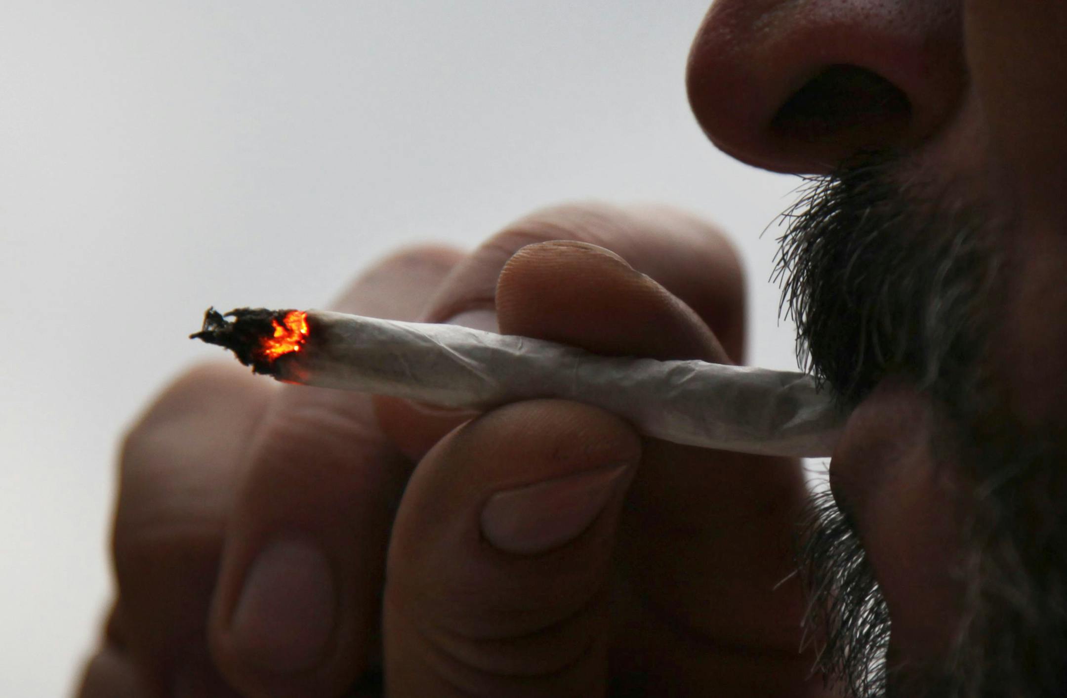 A man smokes a marijuana cigarette.