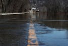Flood waters cover Highway 19, where the Minnesota River is causing flooding and has closed down three of four highways heading into town Wednesday, M