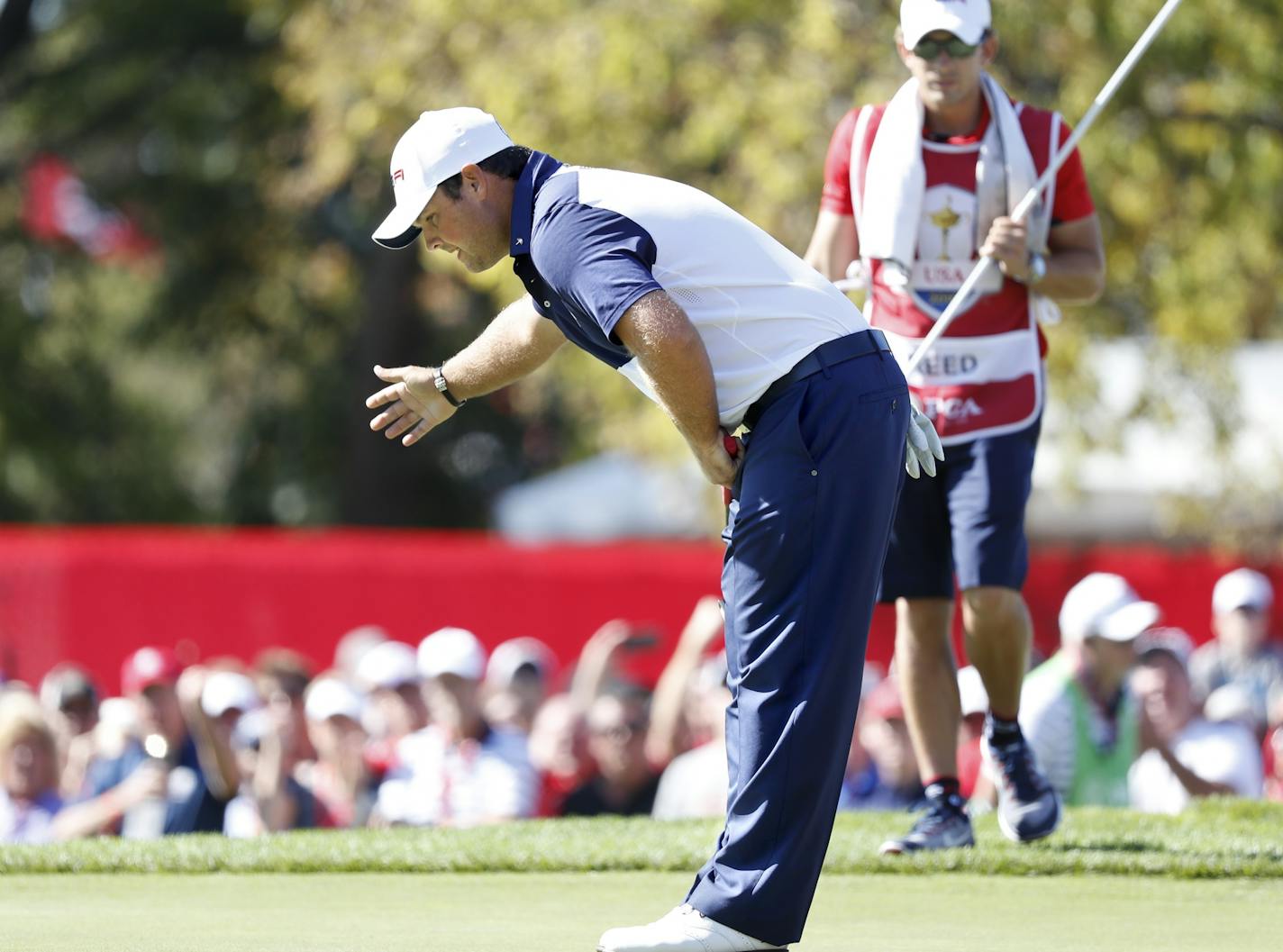 USA golfer, Patrick Reed reacts a bow after making a putt 5th to go all-square with european, Rory McIlroy, Sunday morning in a match.