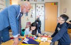 Joe Gothard, the St. Paul Public Schools Superintendent, helps a student, whose parents asked not to be named, with his reading exercise in Rosie Malo