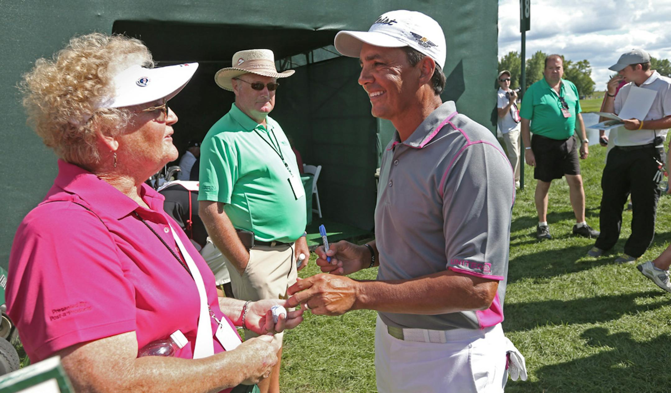 (left to right) Volunteer Sally Altman of Mora, MN., smiled after getting an autographed golf ball from Tom Pernice Jr. after he finished the 2nd round of the 3M Championship at the TPC in Blaine, MN., on 8/3/13.