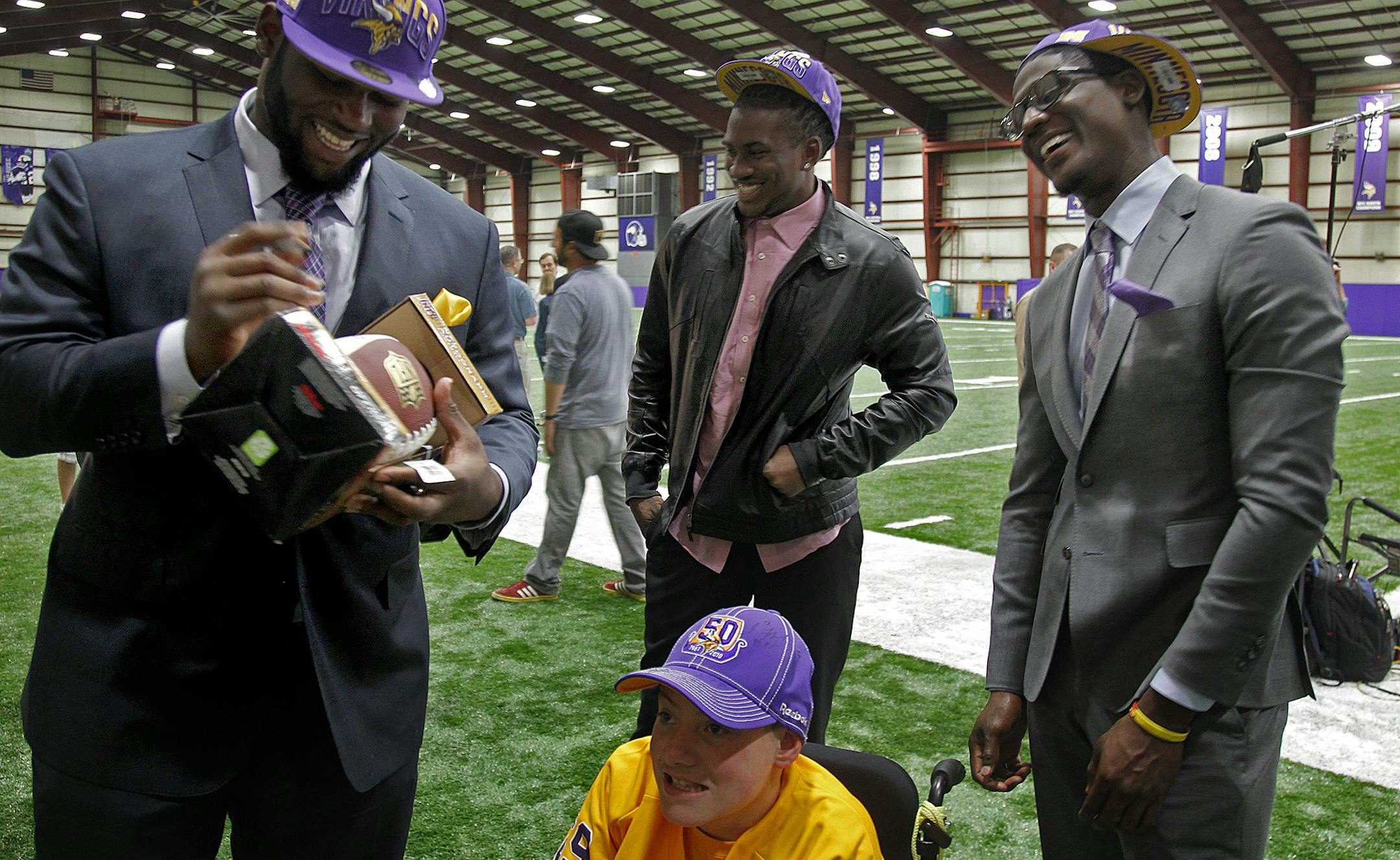 Children's Hospital patient, Shane Swanson of Bloomington was surrounded by the newest Vikings including, Sharrif Floyd, left, Cordarrelle Patterson, center, and Xavier Rhodes, right at Winter Park after they were introduced to the media in Eden Prairie, MN, Friday, March 26, 2013. Swanson, who was born with spina bifida, was there with his parents Wendy and Mark Swanson of Bloomington, MN. (ELIZABETH FLORES/STAR TRIBUNE) ELIZABETH FLORES • eflores@startribune.com