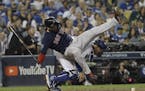 Boston Red Sox's Eduardo Nunez is upended by Los Angeles Dodgers catcher Austin Barnes while Barnes tried to field a wild pitch during the 13th inning
