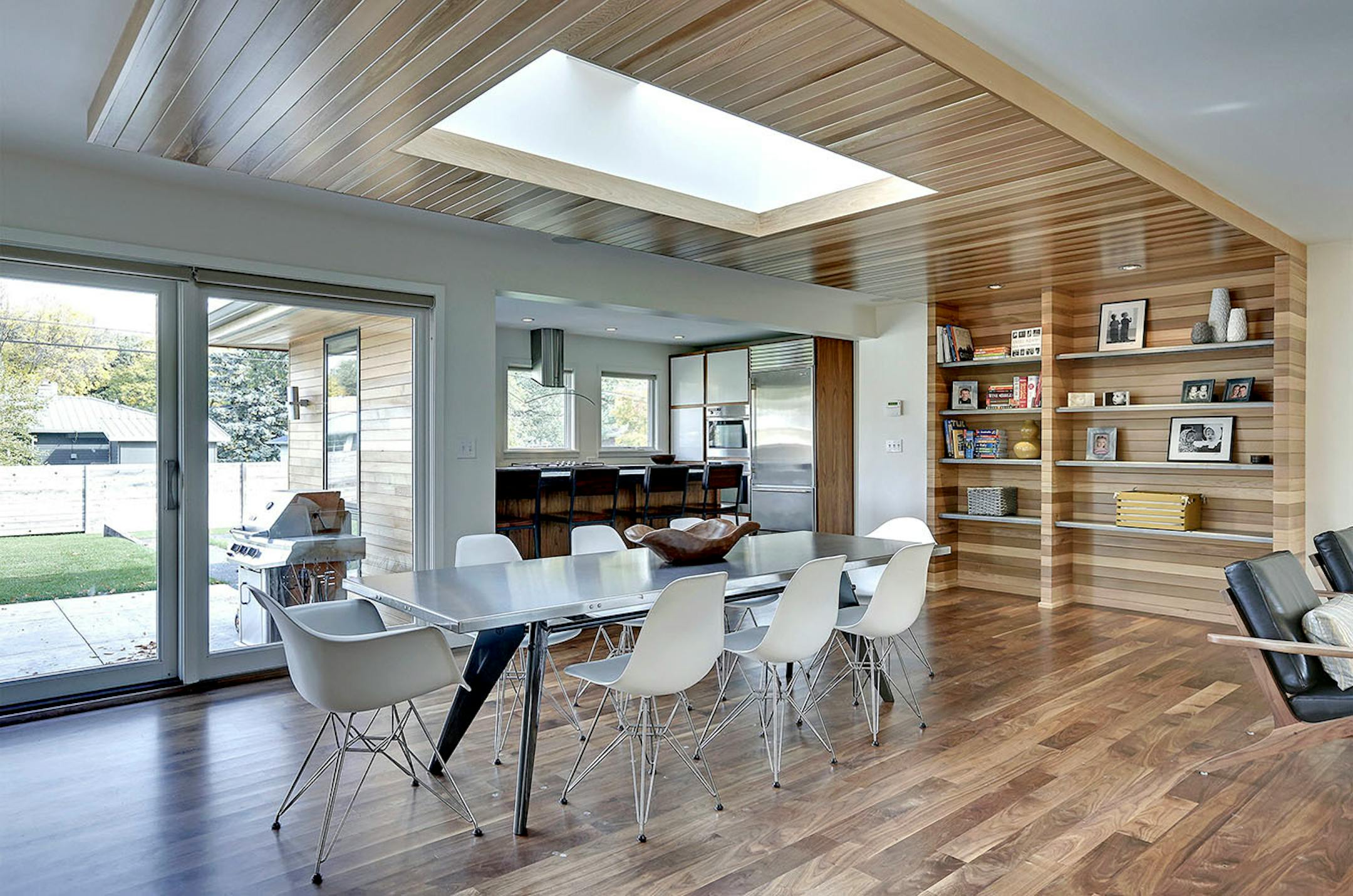 Peterssen/Keller designed a cedar centerpiece that wraps around a double skylight, then continues down the wall to form built-in bookshelves. .