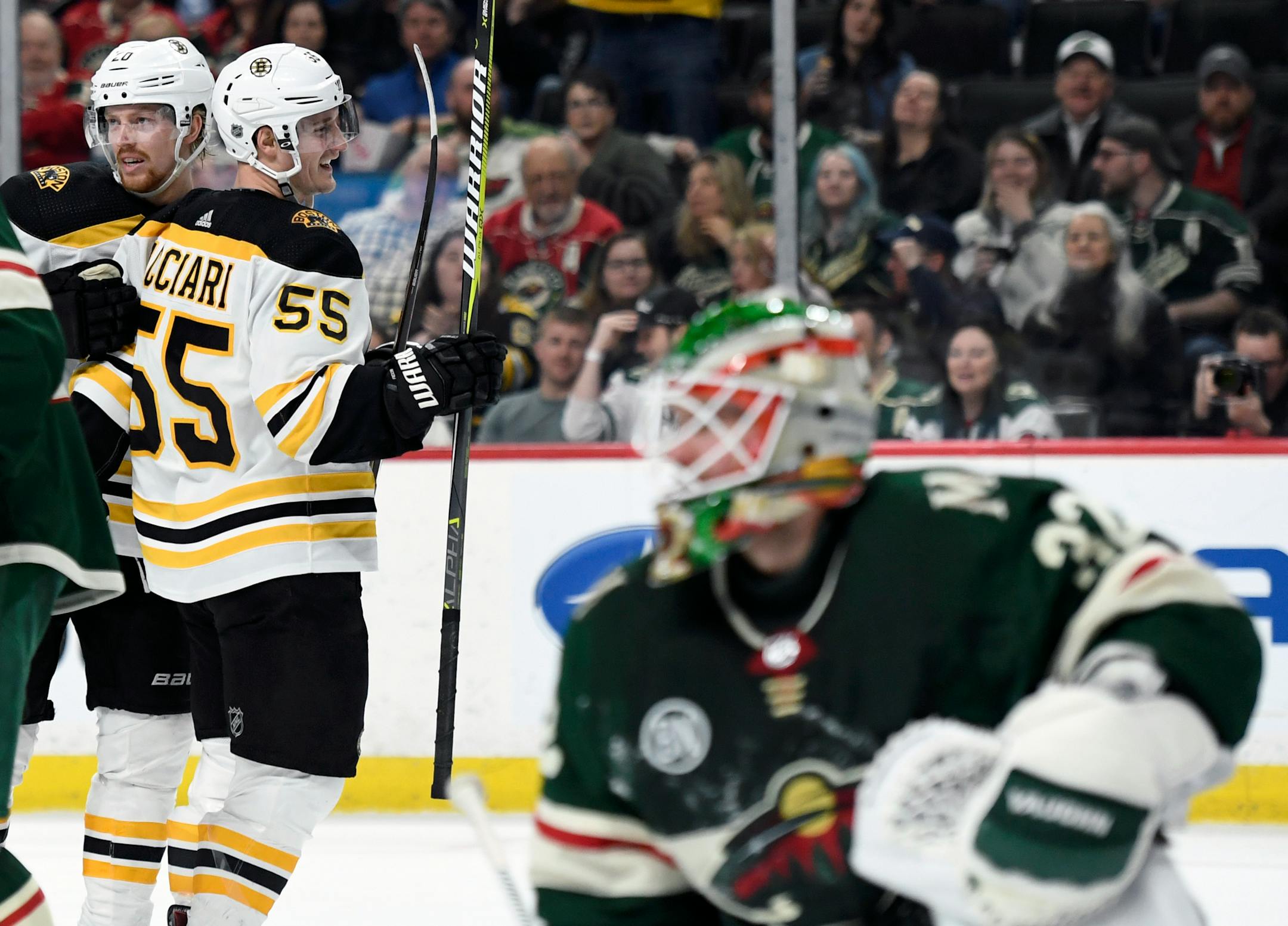 Boston's Noel Acciari (55) congratulates Joakim Nordstrom (20) for scoring a goal as Wild goaltender Alex Stalock