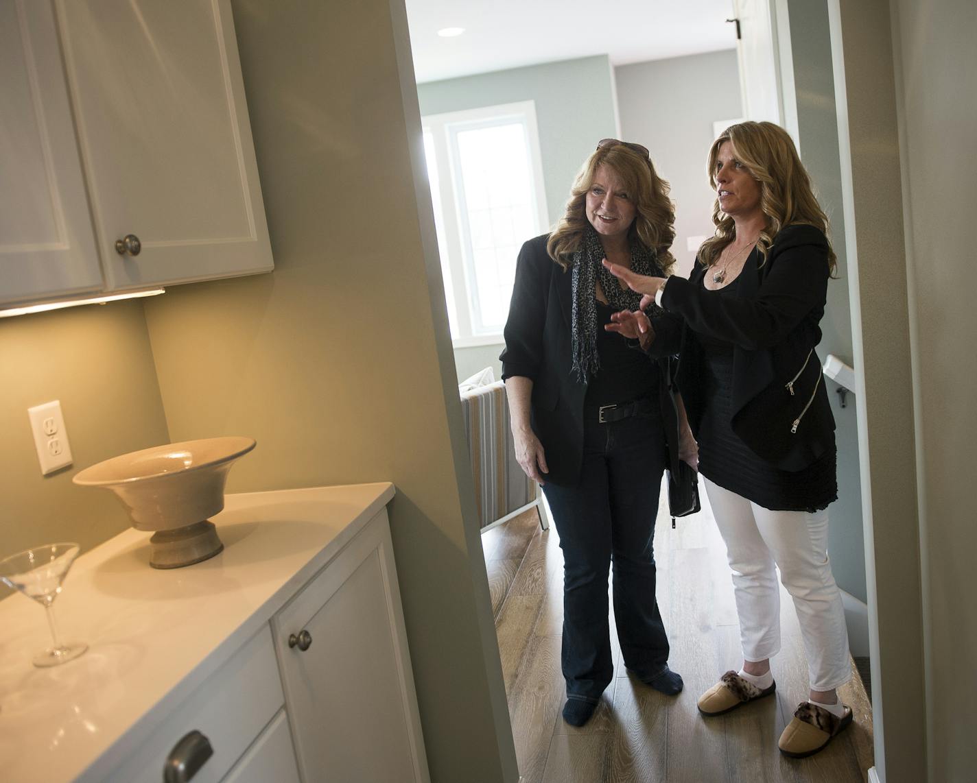 Potential buyer Judy Black, left, was assisted by real estate agent Nicole Reed, as she toured the model home at 4920 Humboldt Avenue North Saturday. ] (AARON LAVINSKY/STAR TRIBUNE) aaron.lavinsky@startribune.com With hundreds of vacant lots, North Minneapolis should be a home builder's paradise. But an imbalance between what houses cost to build and what buyers are willing to pay has made developing those lots difficult. With house prices on the rise, Bob Lux thinks the time is right for new ho