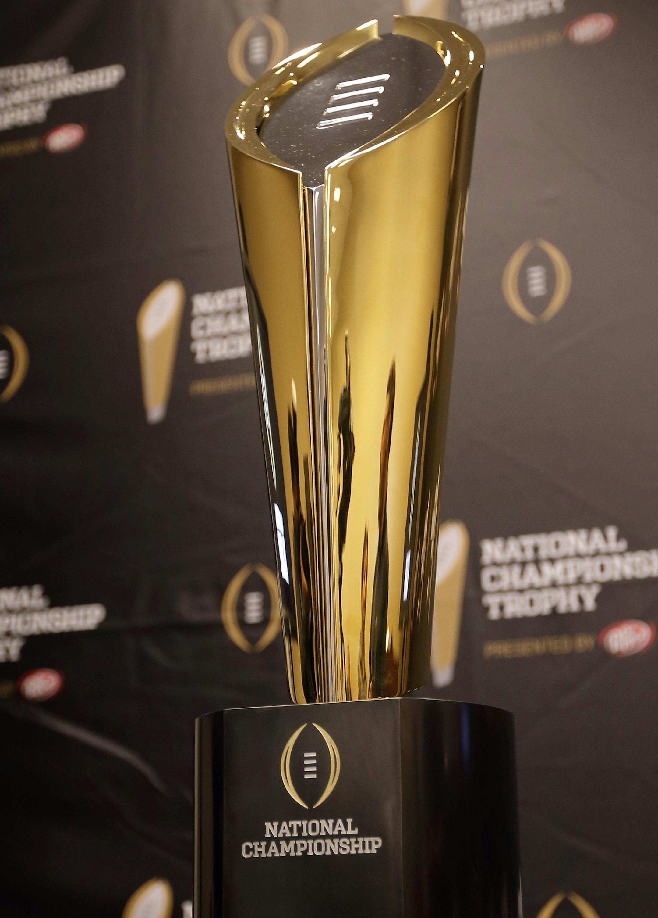This Monday, July 14, 2014 photo shows the College Football Playoff National Championship Trophy in Irving, Texas. A rising gold football-shaped trophy will be the prize for the national champion in the new College Football Playoff. (AP Photo/Tony Gutierrez) ORG XMIT: NYOTK ORG XMIT: MIN1408241802217757