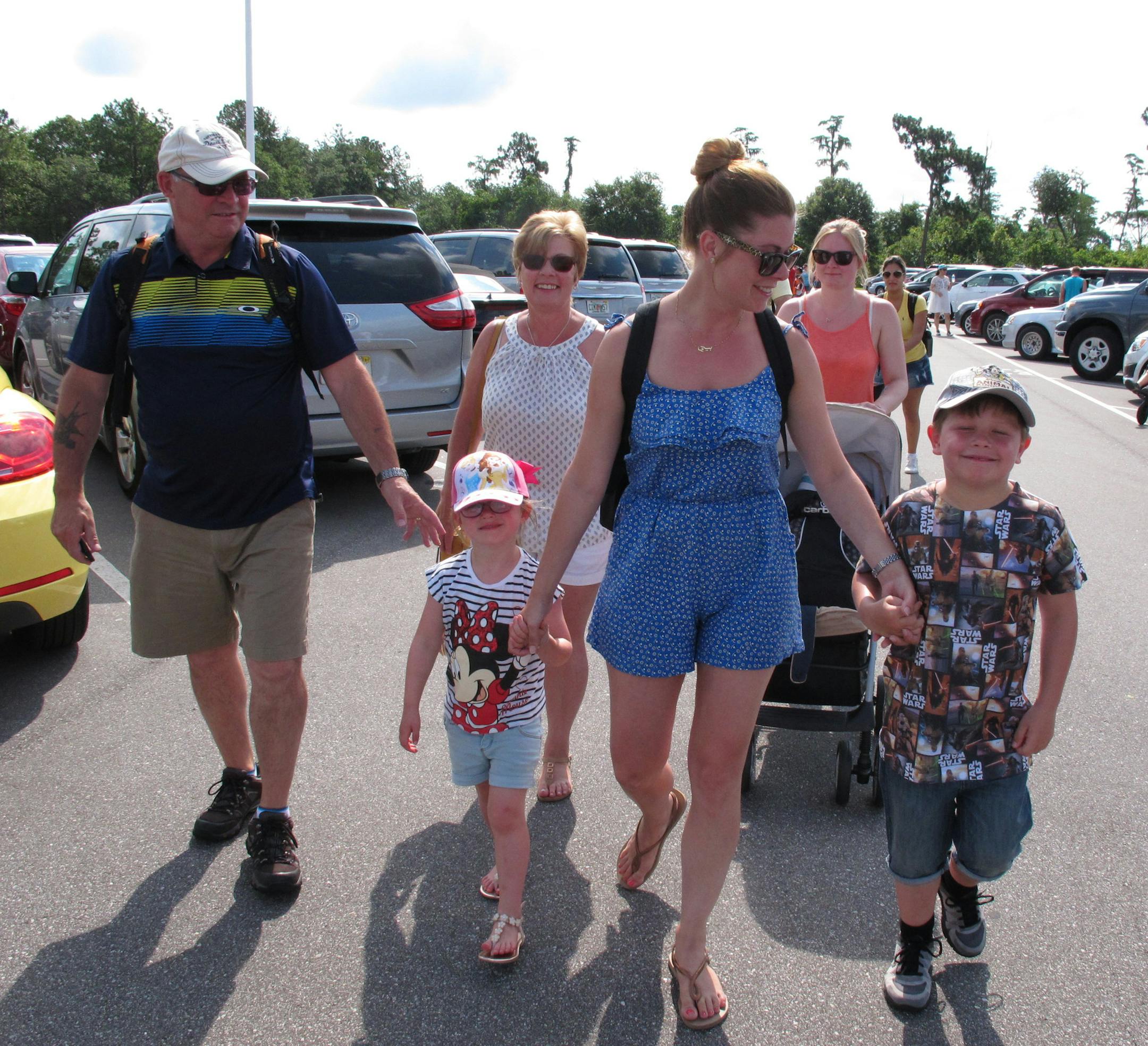 Laura Hakami leads her children, Amelia, 5, and Oliver, 7, into Disney World's Magic Kingdom at Lake Buena Vista, Fla., on Monday, June 13, 2016. The family saved three years for their dream vacation and didn't want to let Sunday's mass shooting at an Orlando nightclub stop them from giving the kids their treat. (AP Photo/Allen G. Breed)