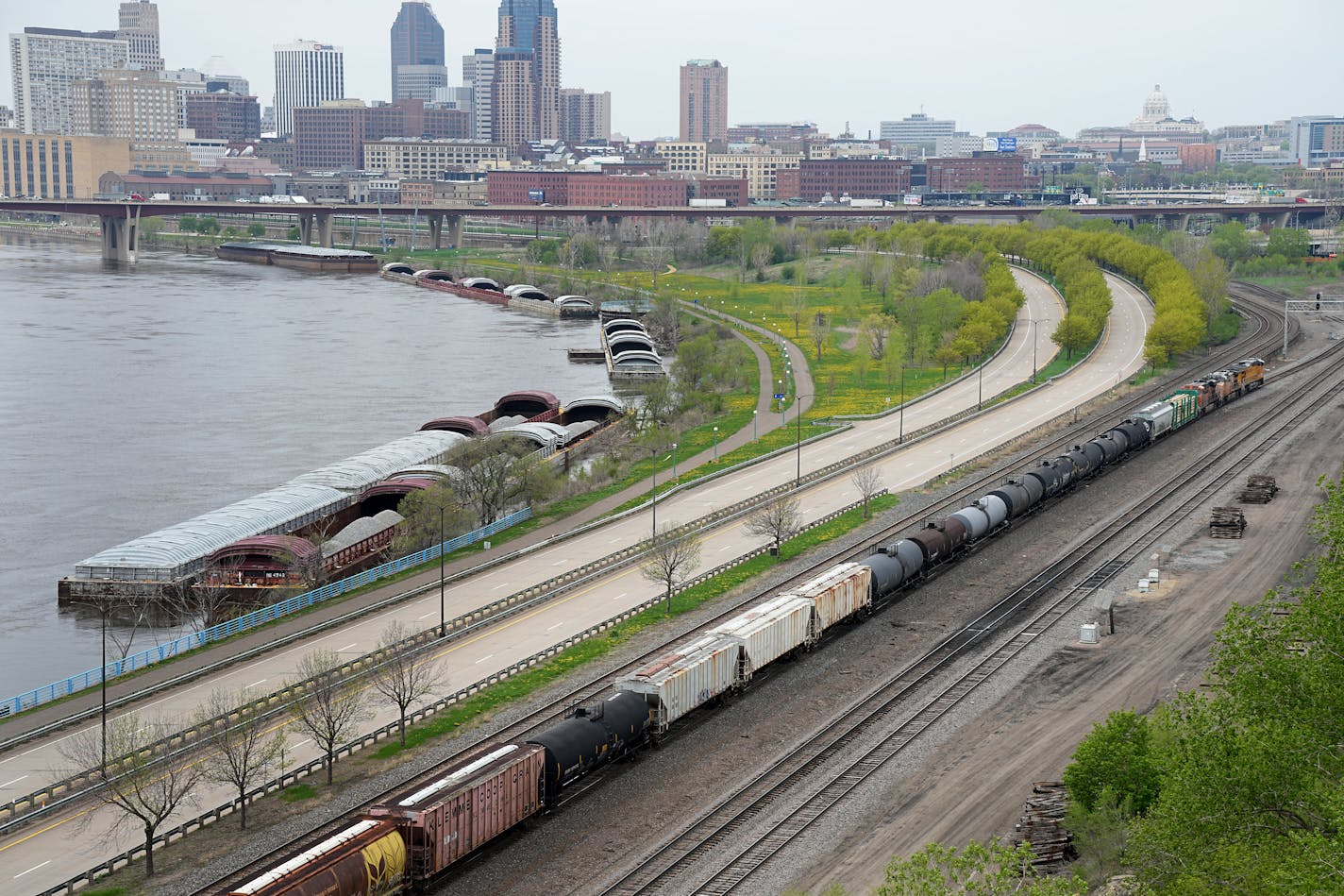 Railroad cars along the Mississippi River with downtown St. Paul in the background.