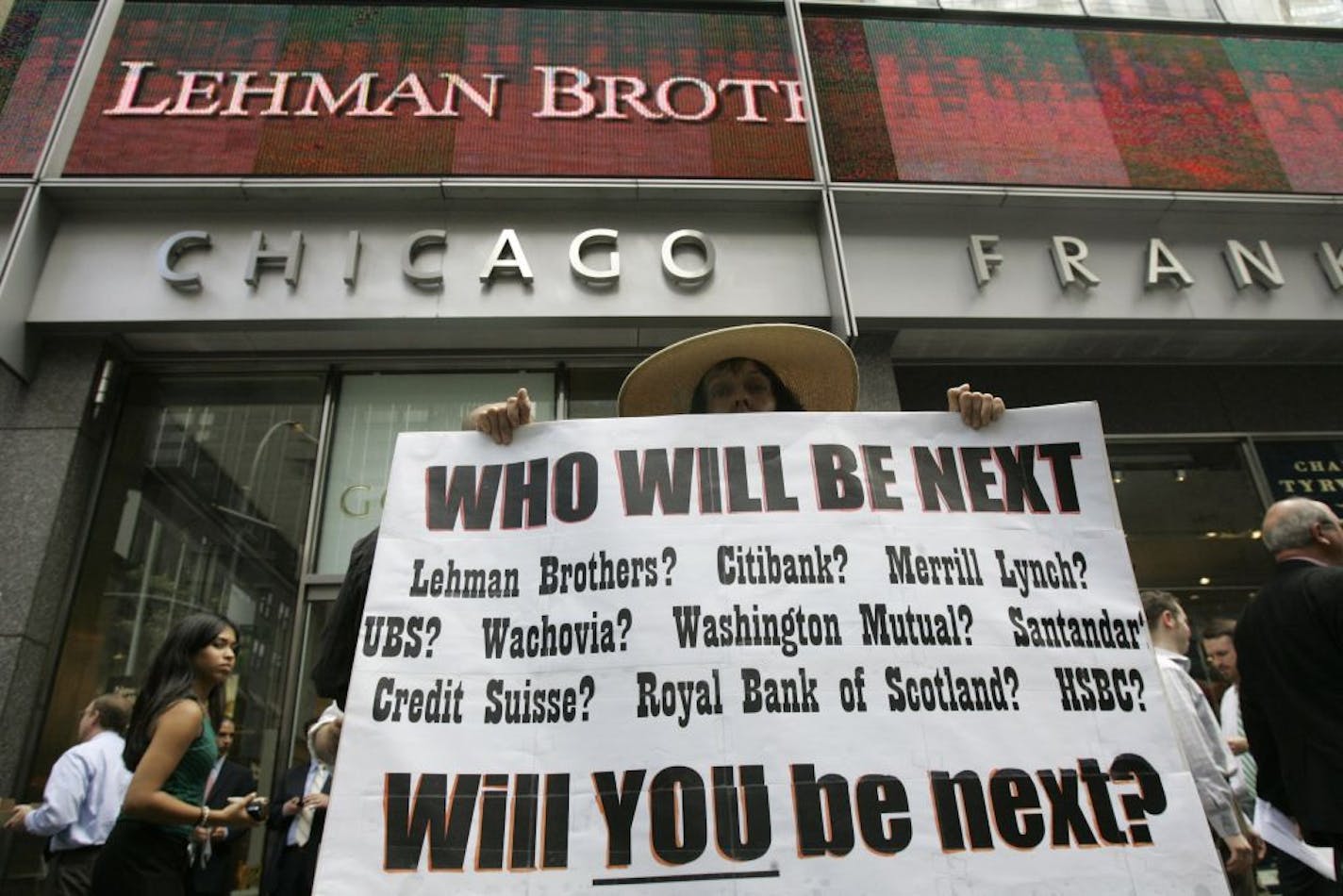 FILE - In this Monday, Sept. 15, 2008 file photo, Robin Radaetz holds a sign in front of the Lehman Brothers headquarters in New York. That day, Lehman Brothers, a 158-year-old investment bank choked by the credit crisis and falling real estate values, filed for Chapter 11 protection in the biggest bankruptcy filing ever.